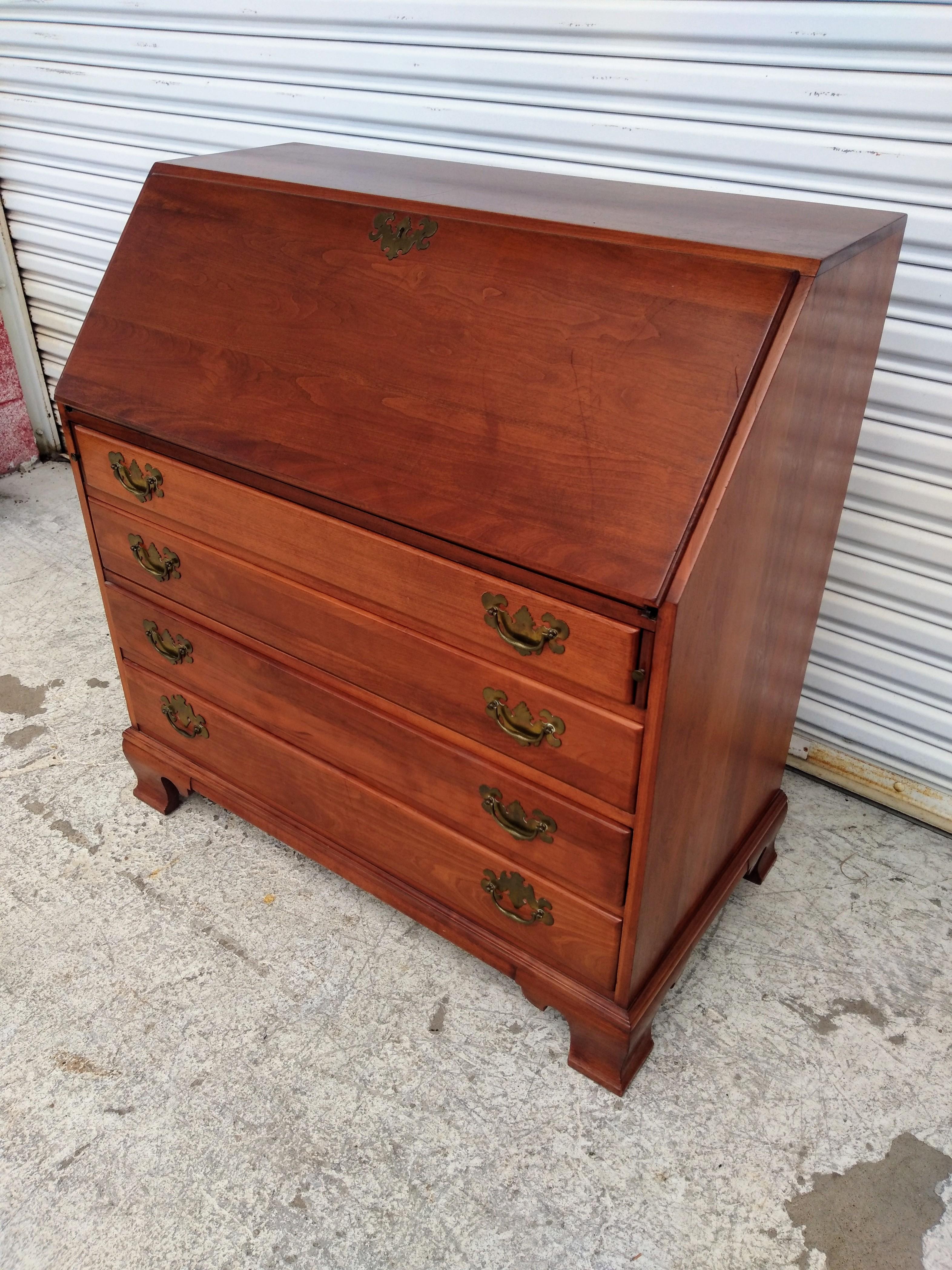 Questo è uno scrittoio della Willett Furniture Co. È realizzato in un ricco legno di ciliegio con tiranti in ottone. Ha un piano inclinato che si apre per esporre cassetti e scomparti per conservare i documenti importanti. Dispone di 4 cassetti per