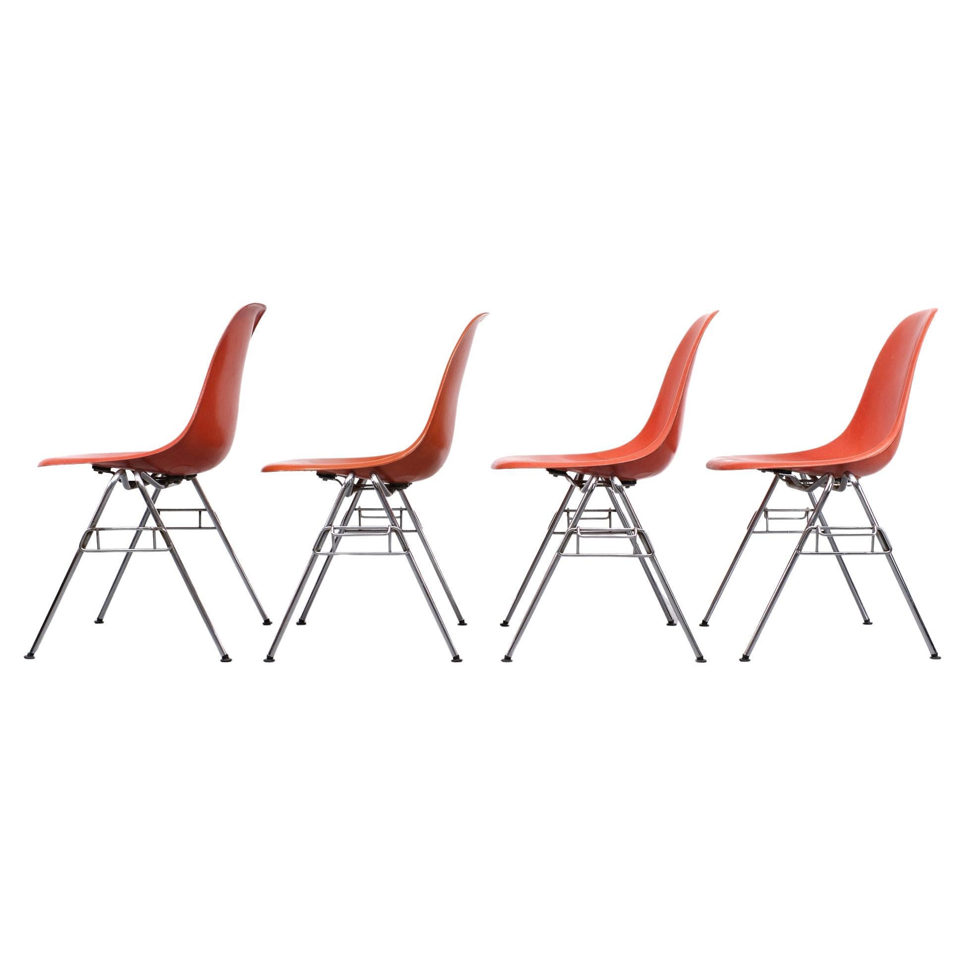 4 chaises empilables DSS en fibre de verre. Charles et Ray Eames pour Herman Miller 1970. 
Belle couleur orange vif. Pieds chromés. Chaises vintage originales. Quelques vieilles réparations 
sous les chaises. Toutes les chaises sont