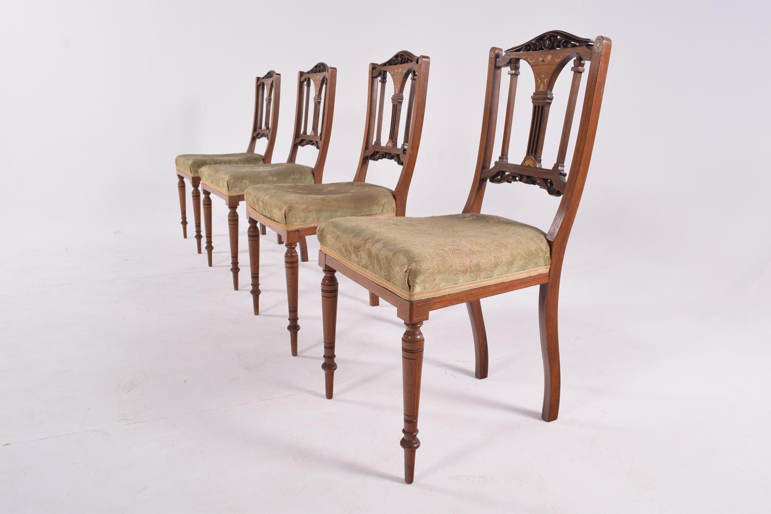 This set of 4 Edwardian rosewood dining chairs features a lovely inlaid top rail. The reupholstered chairs are standing on turned legs to the front and out-swept back legs.