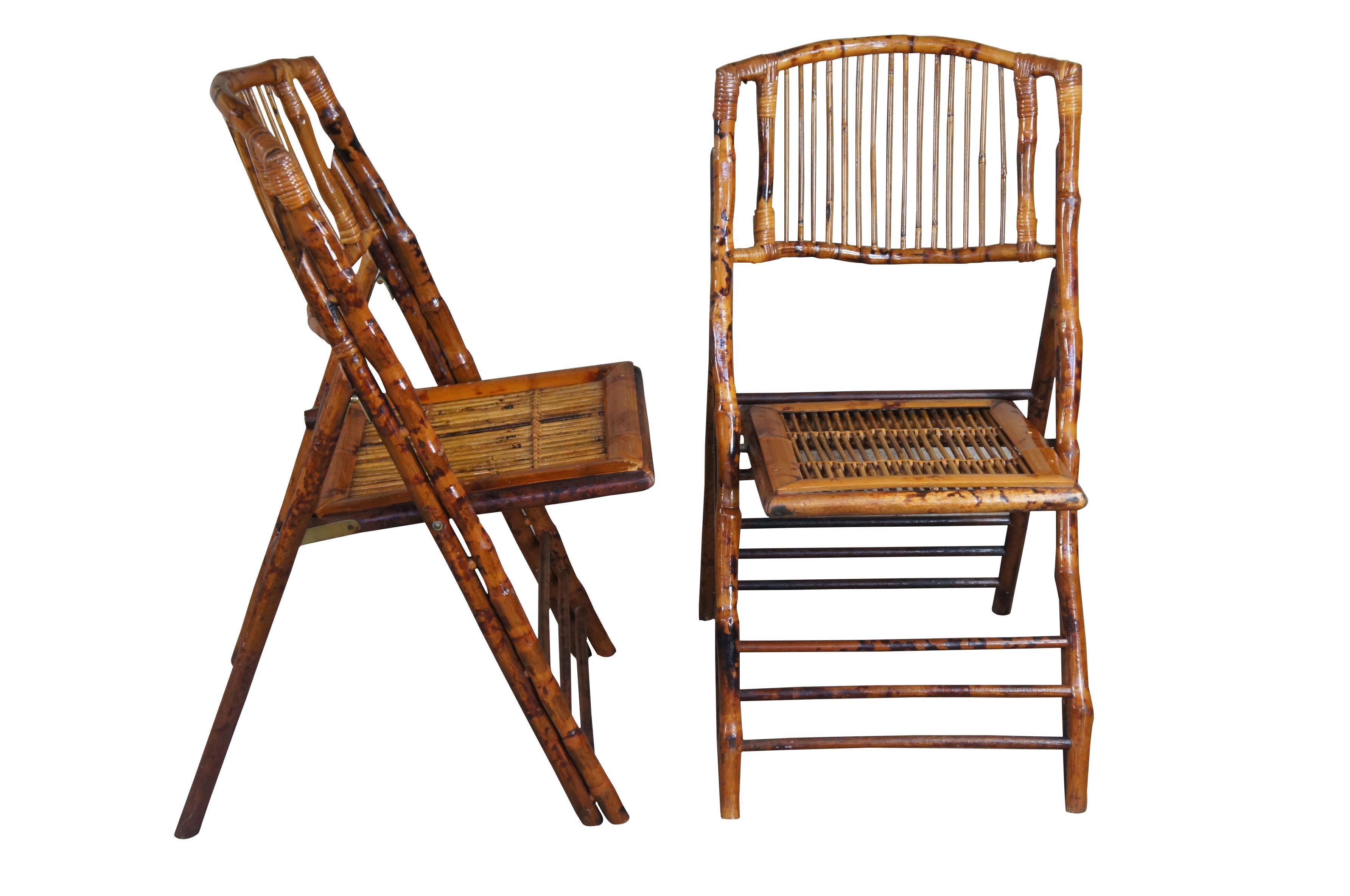 A set of 4 English vintage British Colonial style bamboo folding side chairs from the mid-20th century, with slatted backs and rattan accents. Charming us with their rustic presence and nice patina, this set of mid century bamboo folding side chairs