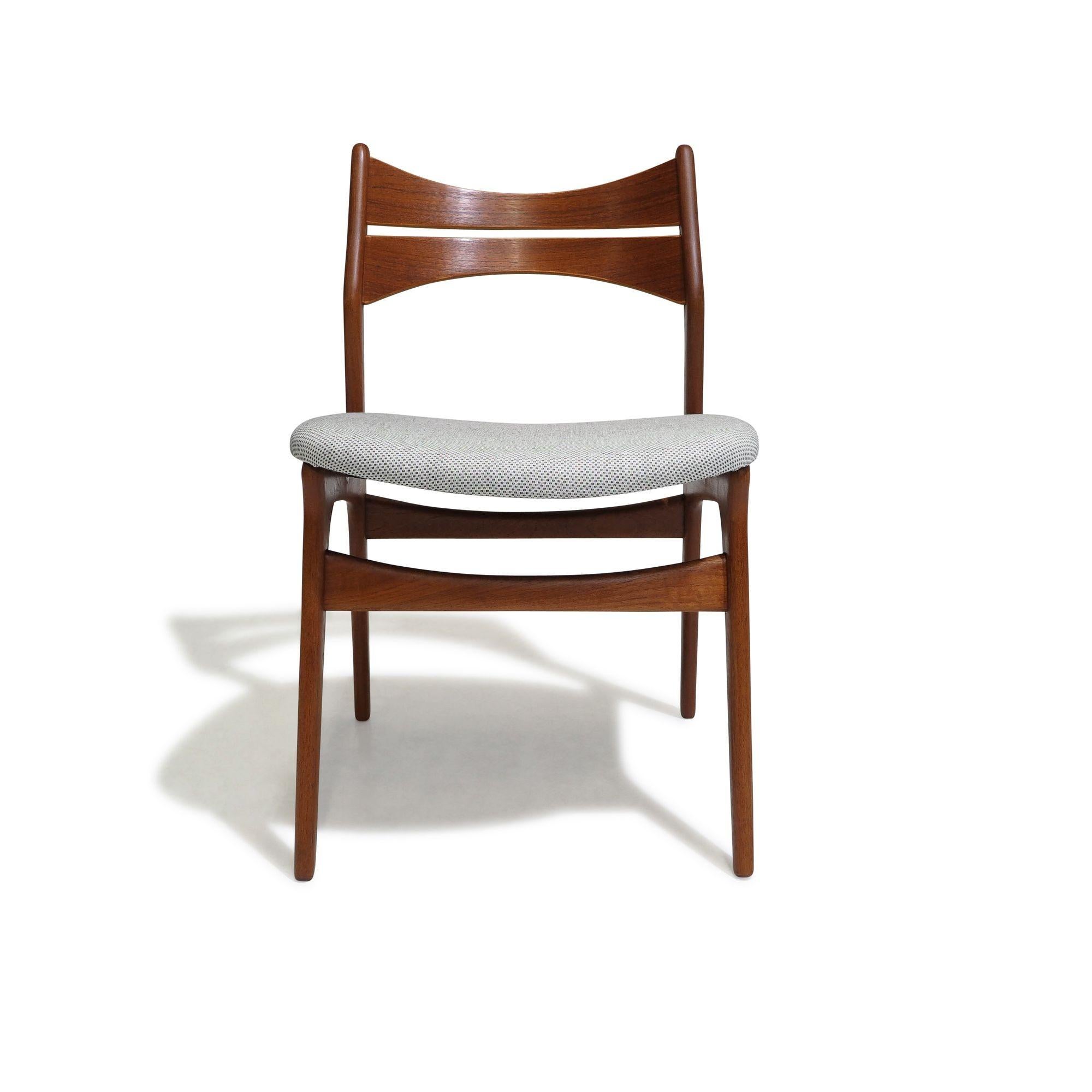 Set of four mid-century teak dining chairs designed by Erik Buch for Christensen Denmark, Model 310. Featuring a solid teak frame with comfortable angled backrests, these chairs have newly upholstered seats in an off-white grey