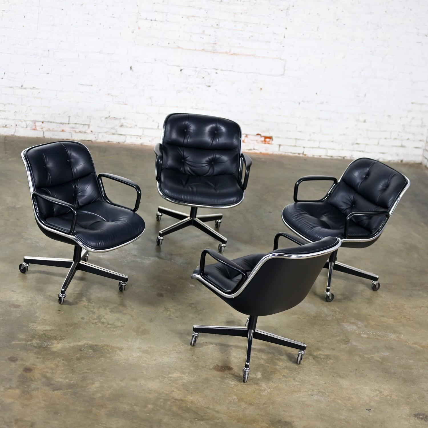 Fabuleux ensemble de 4 fauteuils de direction MCM (Mid-Century Modern) à Modern Executive par Charles Pollock pour Knoll. Chaque fauteuil est composé d'une assise et d'un dossier en cuir noir avec détails de boutons, d'une bande d'aluminium, d'une