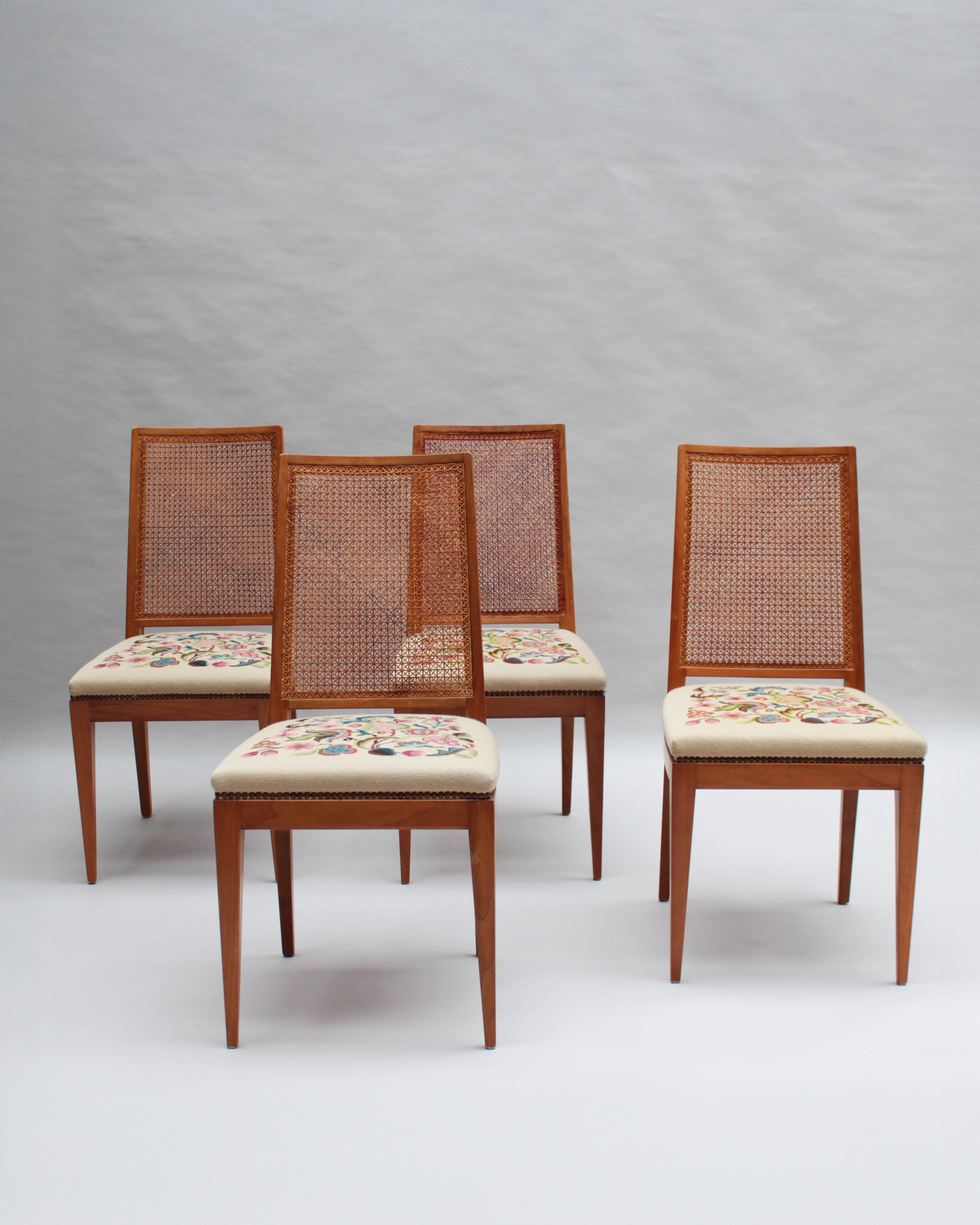 Four fine French Mid-Century cherry side chairs with a caned back and tapestry upholstered seat.

Price is per chair.