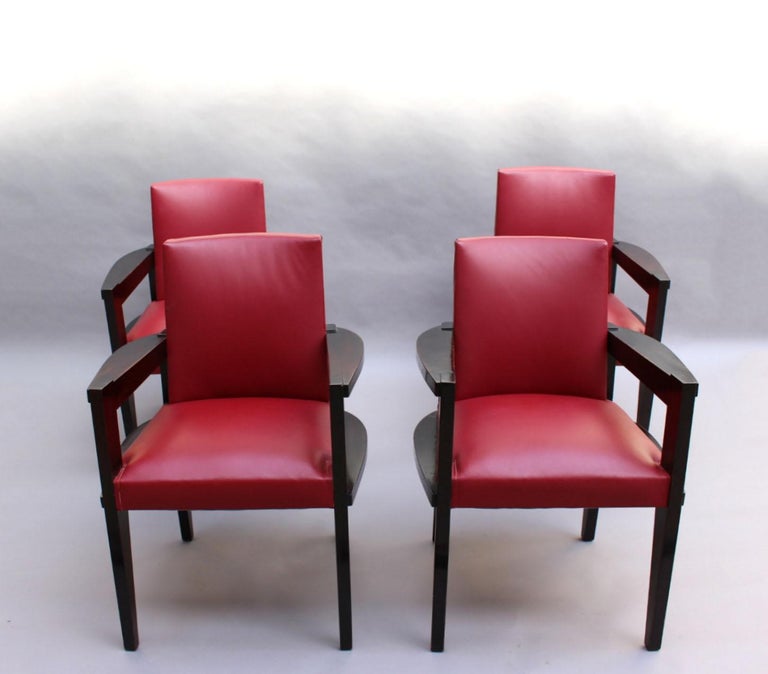 Four fine French Art Deco armchairs by Andre Sornay in blackened mahogany and upholstered with red faux leather.