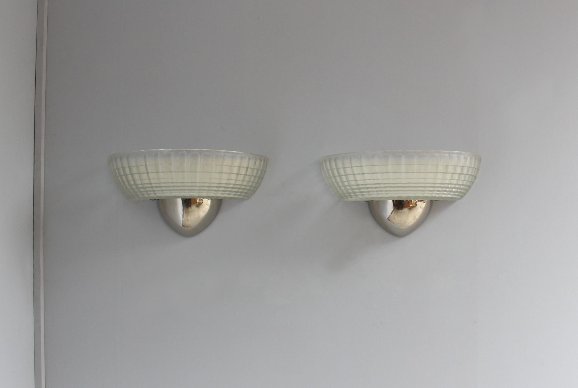 Quattro raffinate applique francesi degli anni '30 con diffusore in vetro olofane montato su una fusione di metallo lucido/cromo.

Il prezzo si intende per luce.
