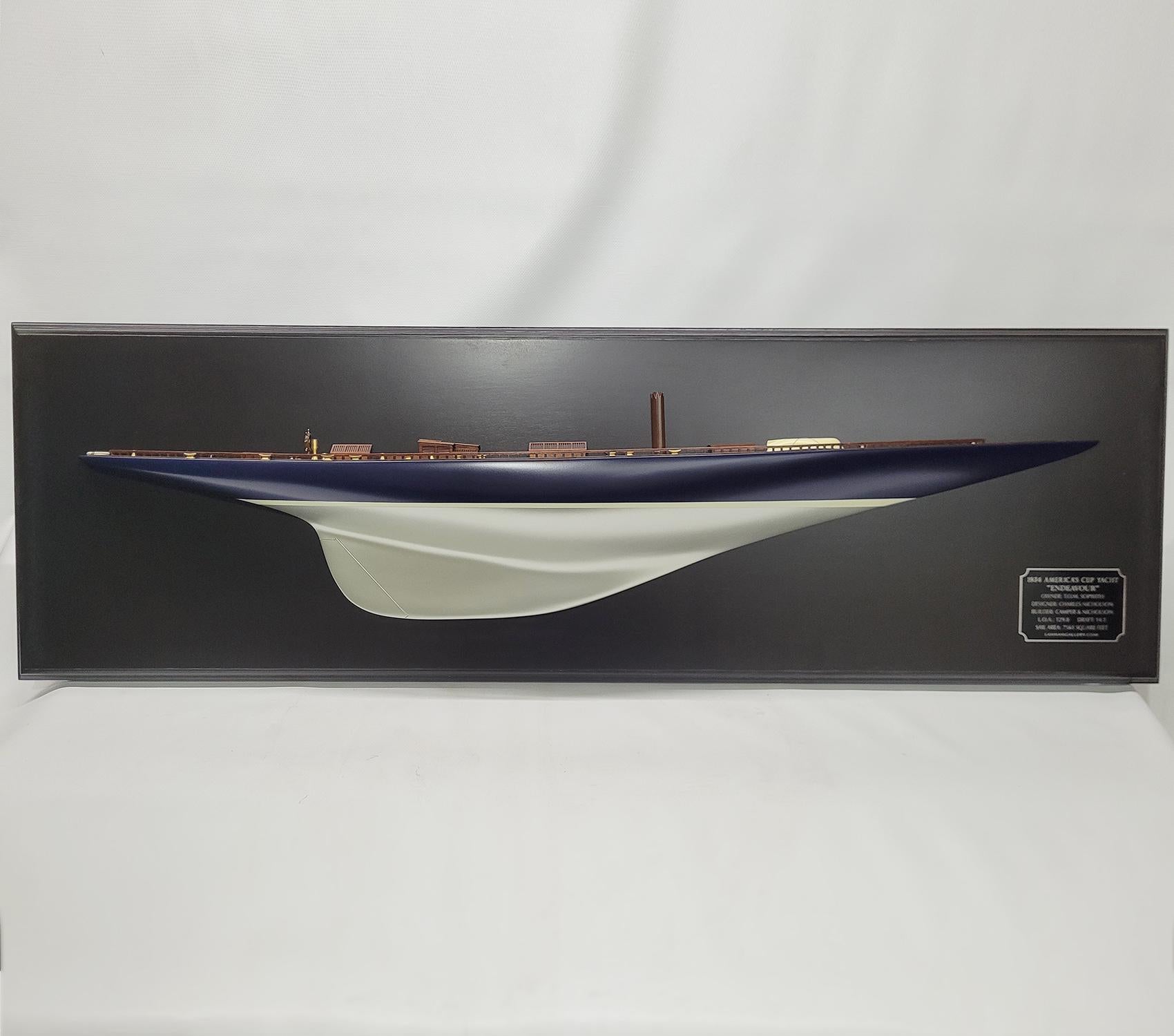 Half model of the America’s cup Yacht Endeavor. This is a 4-foot hull mounted to a blackboard. The Hull is painted blue over silver. The planked deck has skylights, Companionway, Spinnaker pole, Lifeboat, Cleats, Toe rail, Etc. Mounted to a