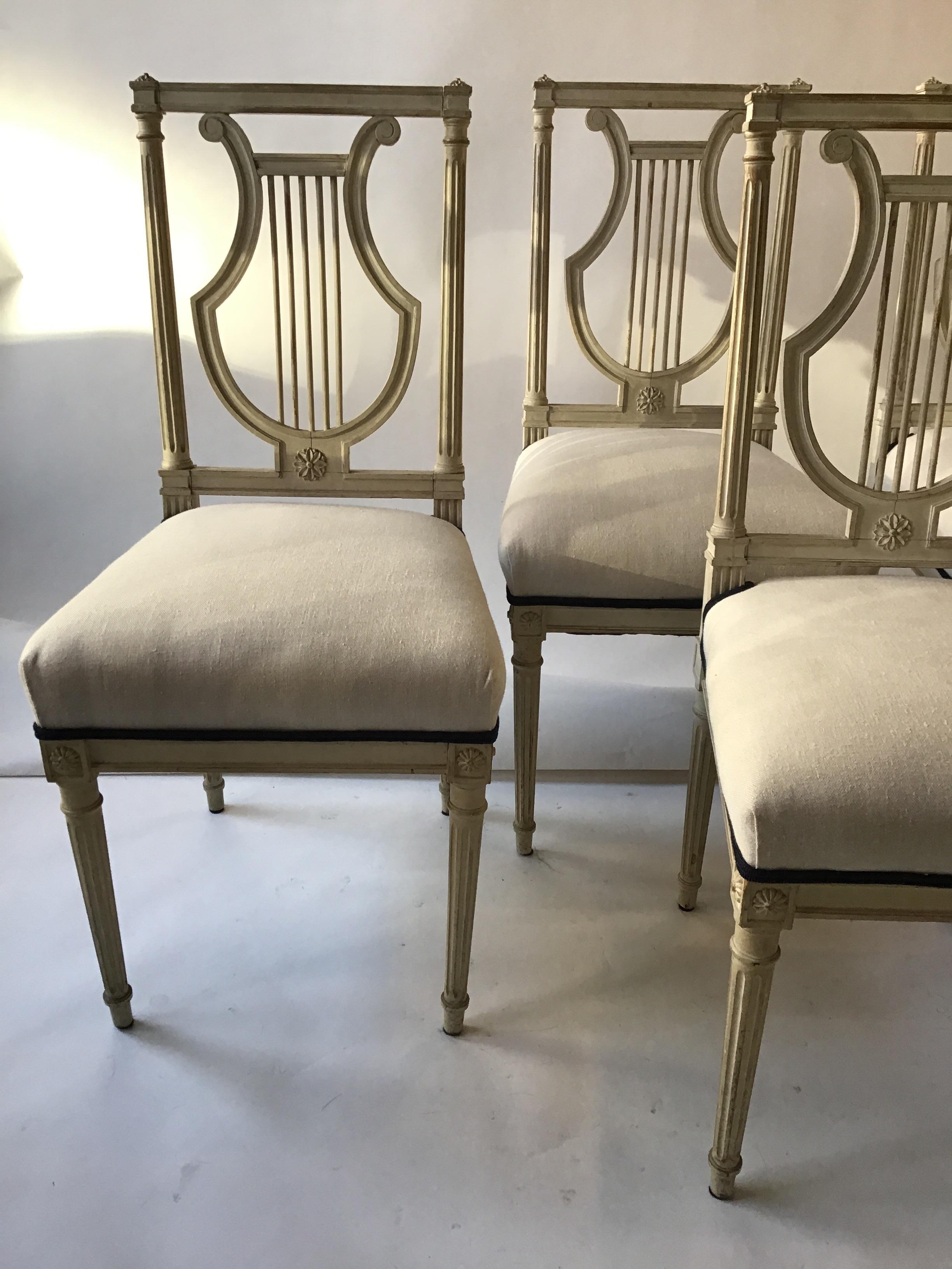 4 French 1950s lyre back side chairs with Louis XVI leg, painted white. Upholstered a few years back.