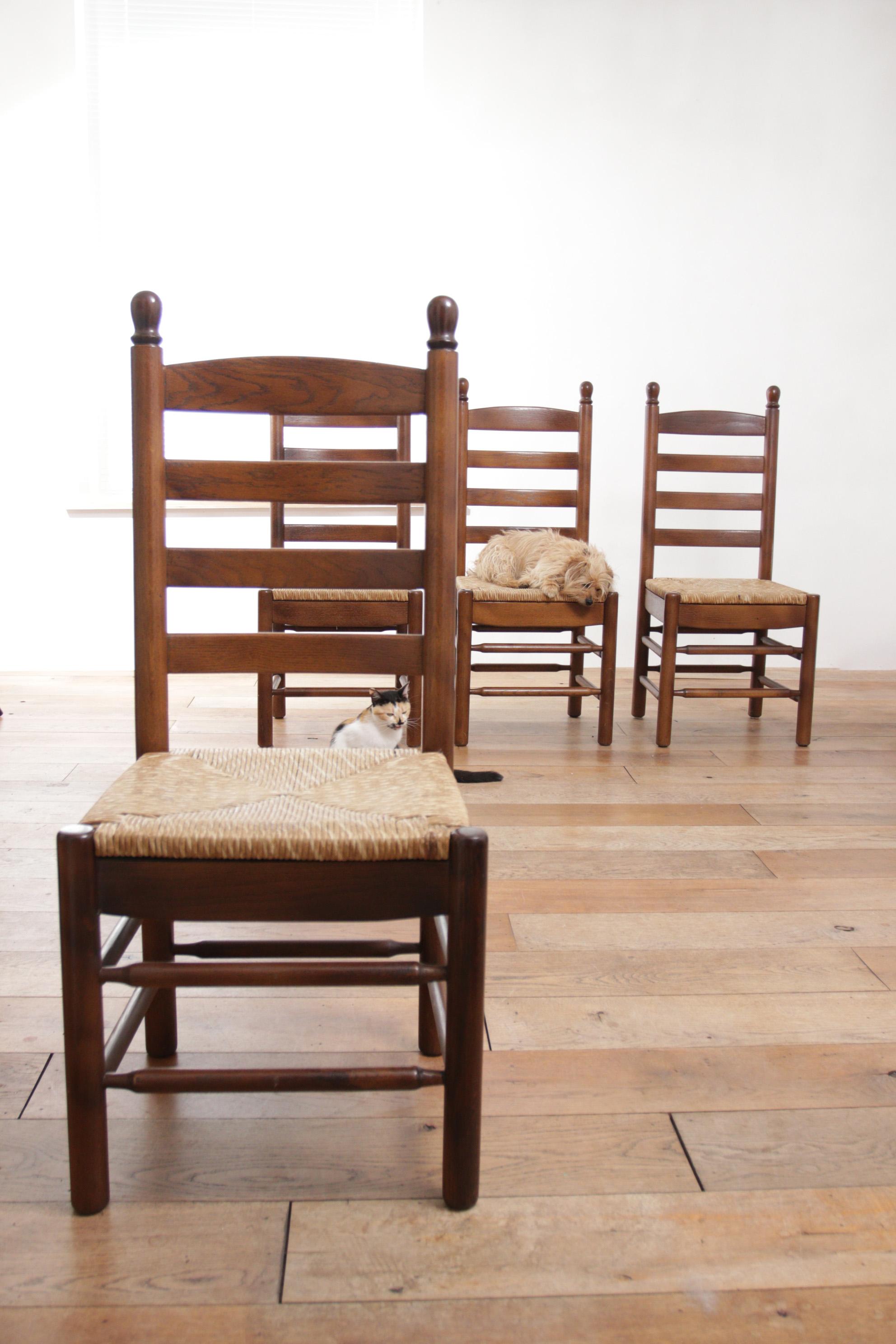 French ladder back oak rush seat dining chairs. Crafted in the 1970s, these beautiful chairs boast a solid oak frame and feature a wicker woven rush seat, offering a harmonious blend of elegance and comfort.

Fits perfect with the furniture of the