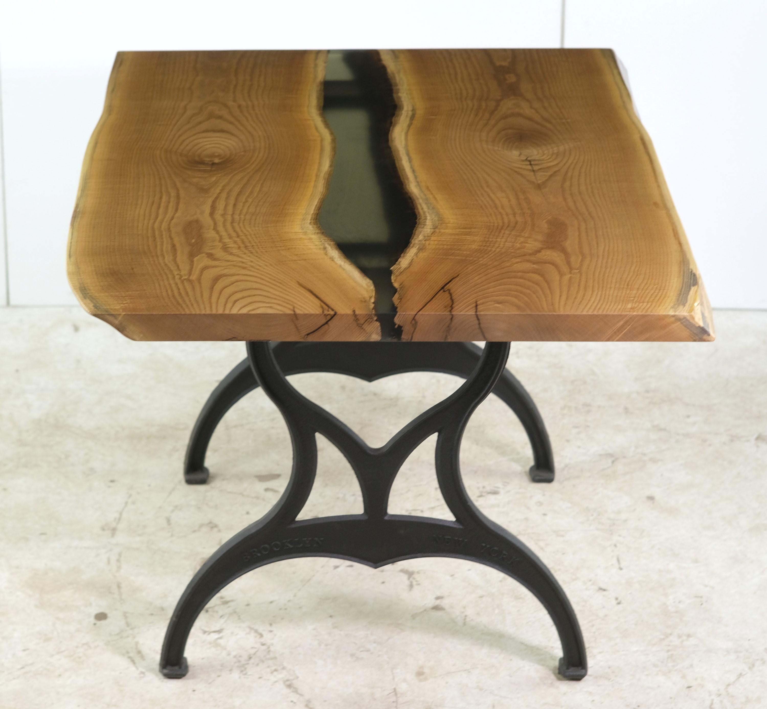 This live edge table features a two slab solid hickory top with pale green resin down the center paired with Industrial style cast iron Brooklyn legs. This table is ready to ship. Please note, this item is located in our Scranton, PA location.
