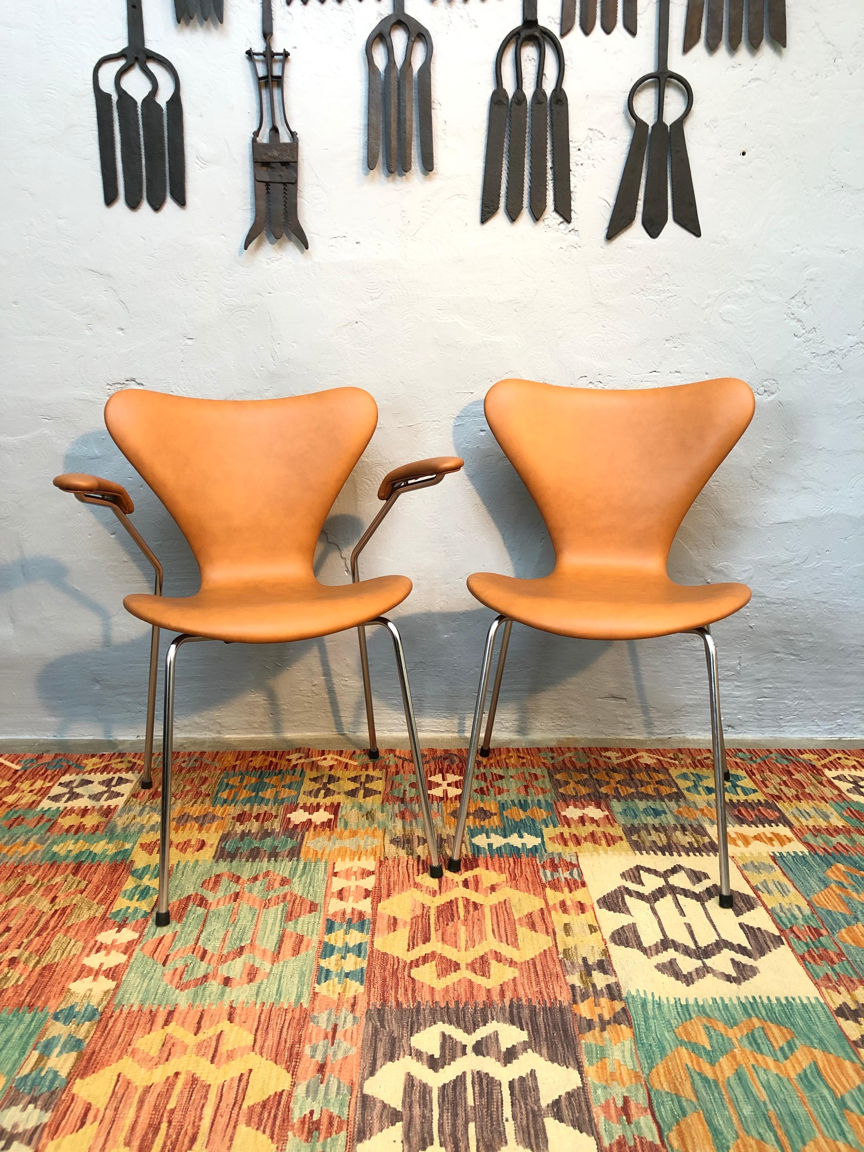 A set of 4 iconic made in Denmark Arne Jacobsen for Fritz Hansen chairs. 
In this set of 4 there are 2 model 3207 with arm rests and 2 model 3107 without. 
Dated and marked on the base 1963/1964. 
This is a very early set of “7” chairs as they are
