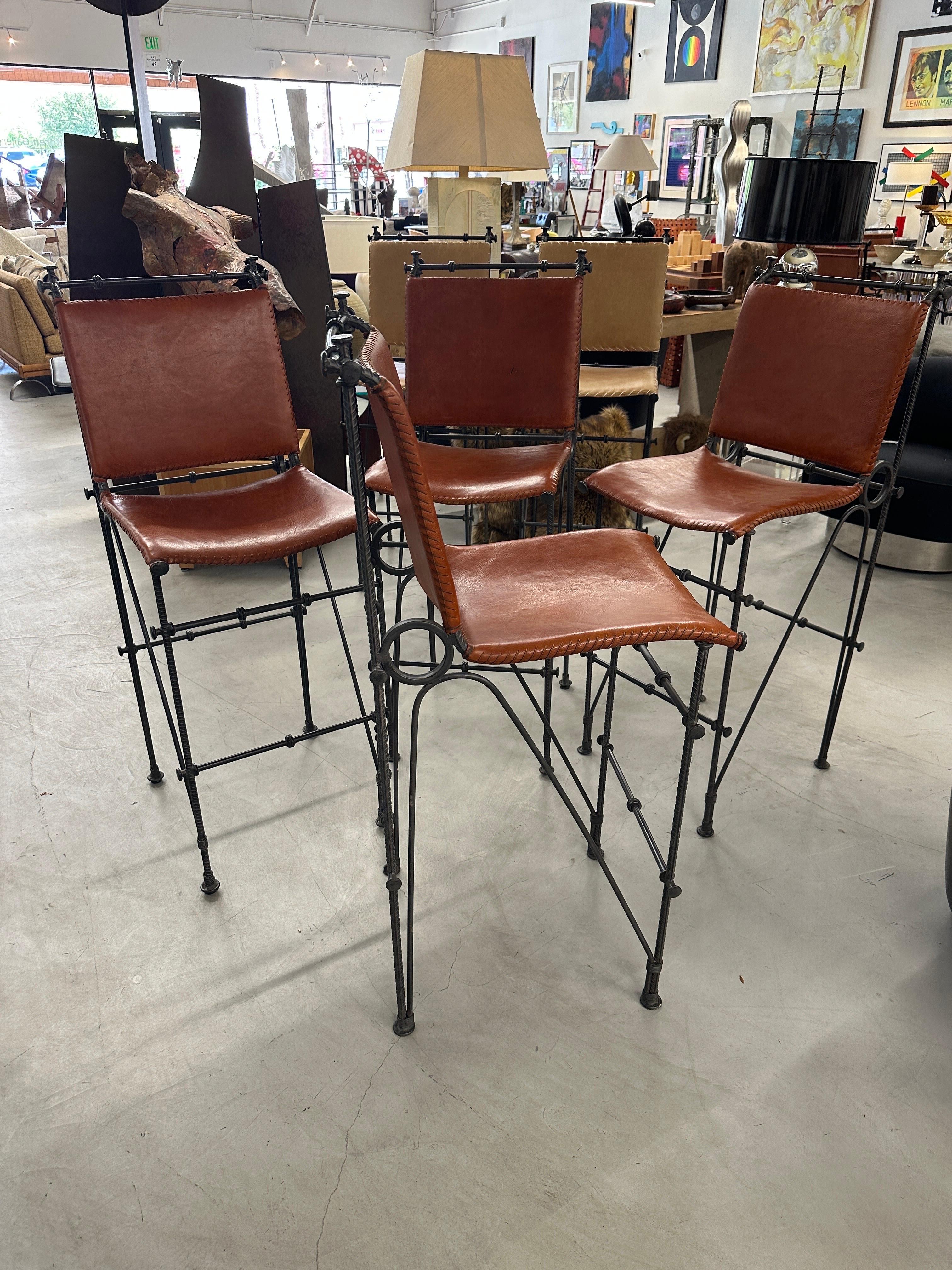 A lovely set of 4 iron and leather stools likely designed by Ilana Goor the noted Israeli designer. beautifully stitched detail. In good original age appropriate condition with a couple of marks to the leather and some paint residue spots on the