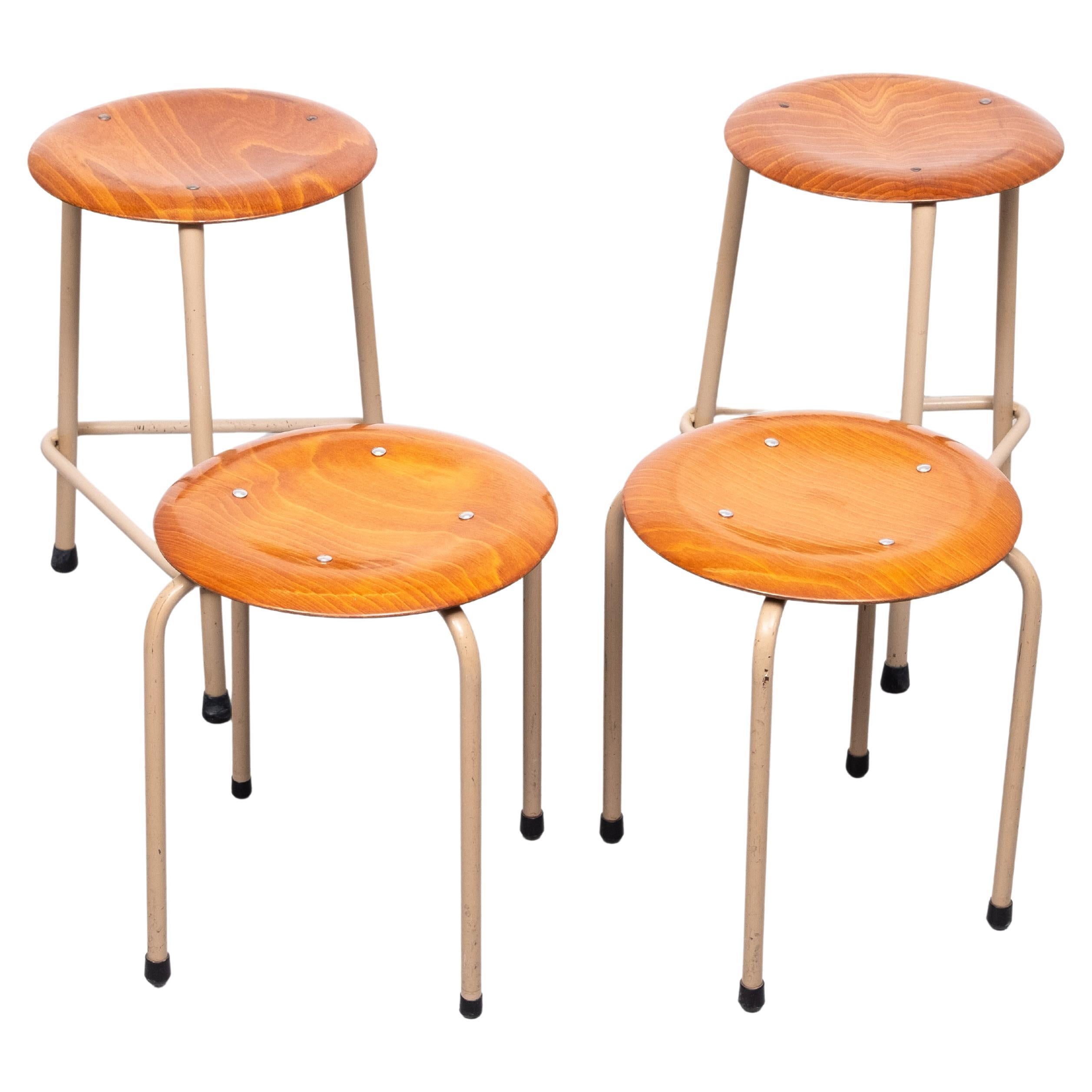 set di 4 sgabelli da lavoro industriali. Prodotto da Marko.
2 più alti con 3 gambe. come il colore marrone chiaro sulle gambe. Piani in compensato di teak .