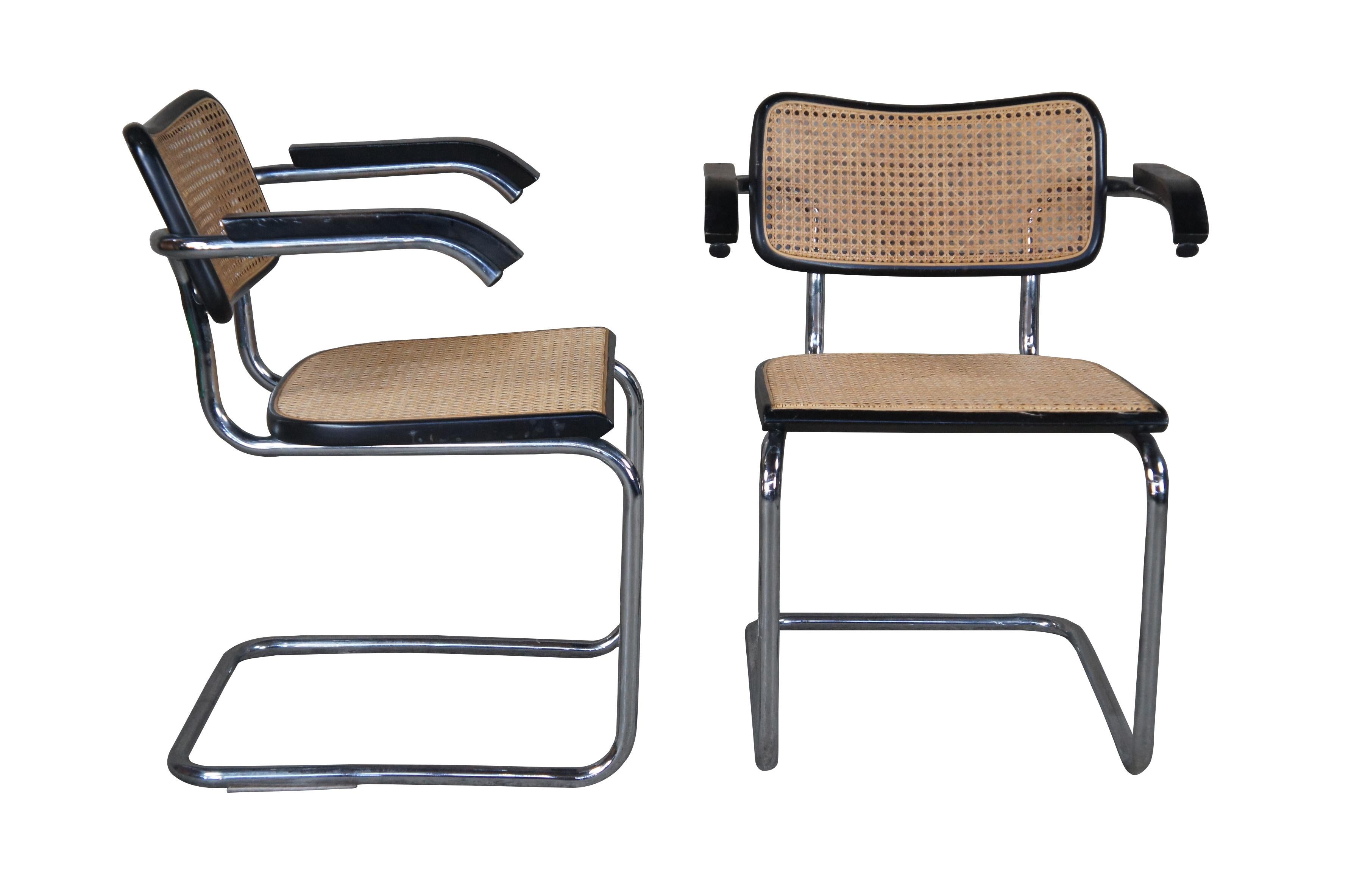 Four vintage Marcel Breuer Cesca Gavina Knoll dining armchairs.  Made of tubular steel / chrome featuring caned seat and back with ebonized frame and arms.   Linearity balanced by subtle curves; wicker caning punctuated by a wooden frame; and a