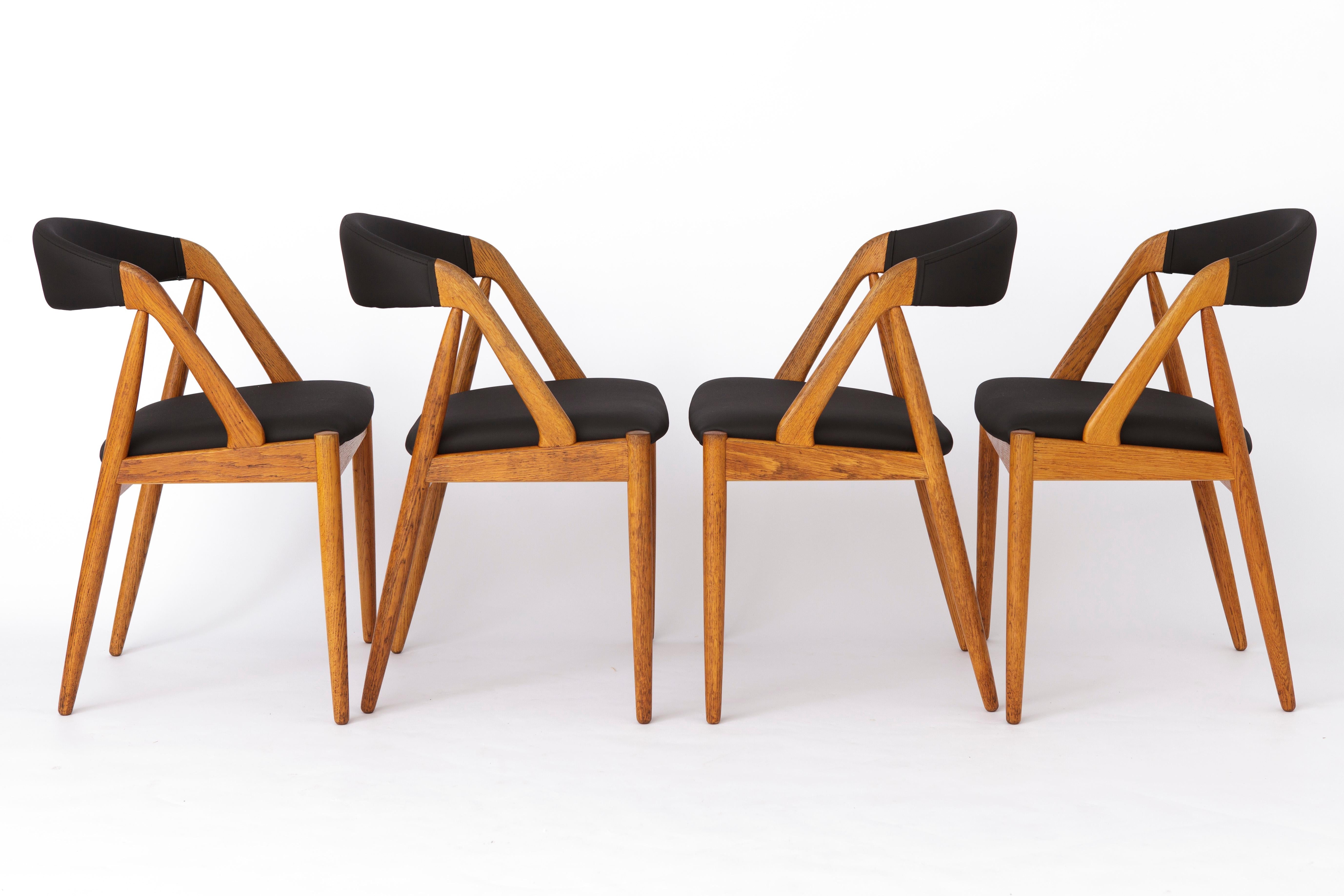 Set of 4 Vintage Chairs designed by Kai Kristiansen.
Model: 31 from the 1960s. 
Displayed price is for a set of 4. 

Very good vintage condition. Sturdy oak chair frames. 
Refurbished and oiled. 
Reupholstered seat and back part with black skai