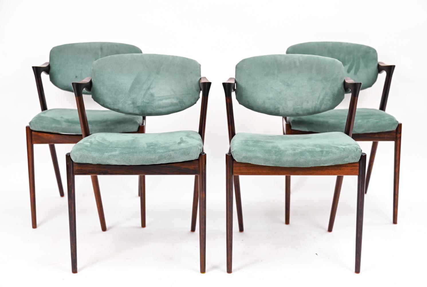 A striking set of four Danish mid-century dining chairs designed by Kai Kristiansen. These iconic Model 42, or 