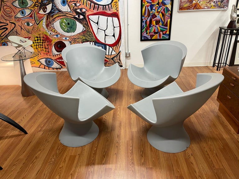 A set of 4 hard to find Karim Rashid designed chairs for Label from 2004. These are grey in color and are each stamped on the base. These all feature drainage holes so they may left outside. They are weather resistant and the color does not fade.