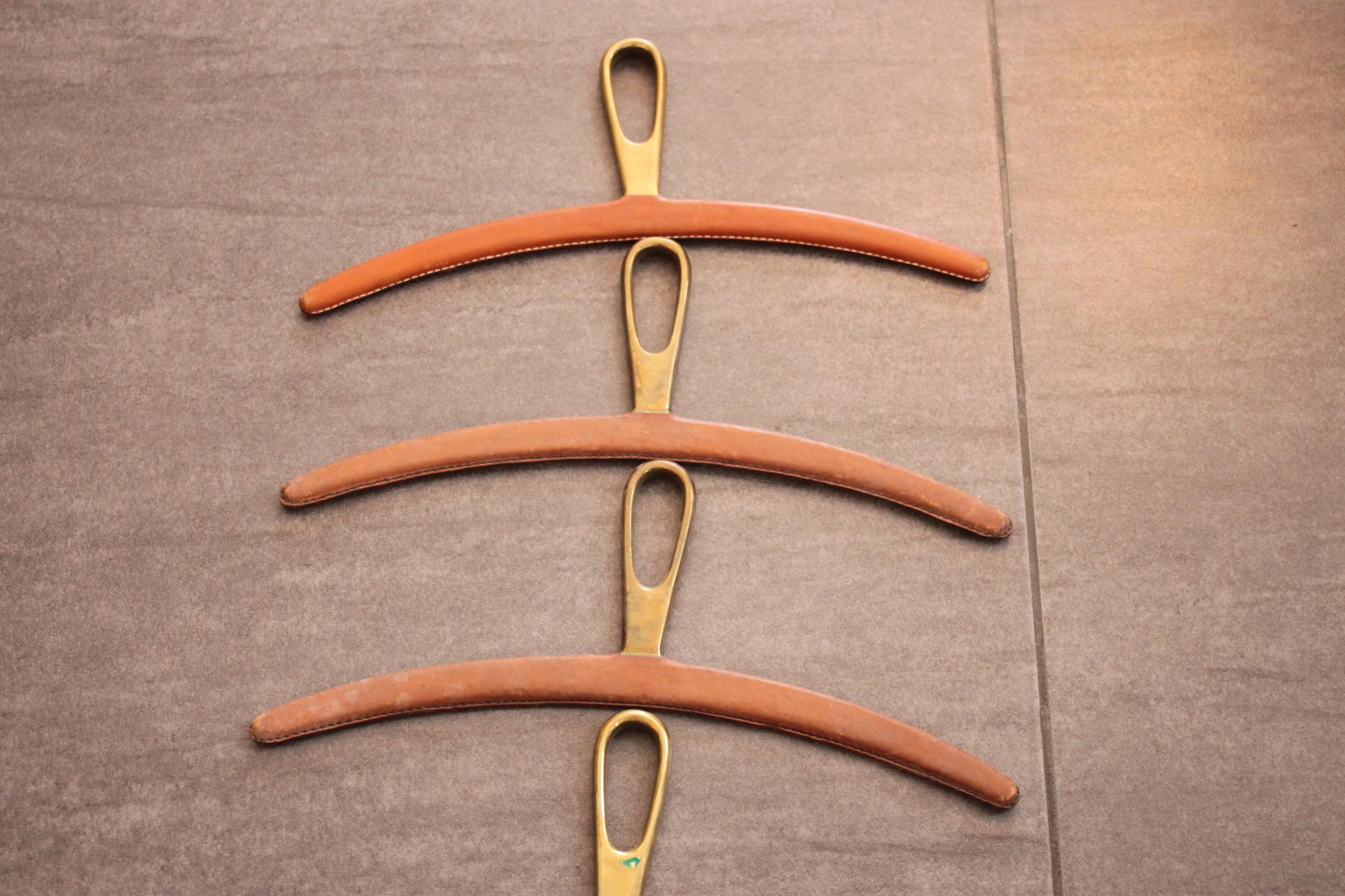 4 leather-coated brass coat hangers by Carl Auböck
Elegant shape and heavy use of massive brass.