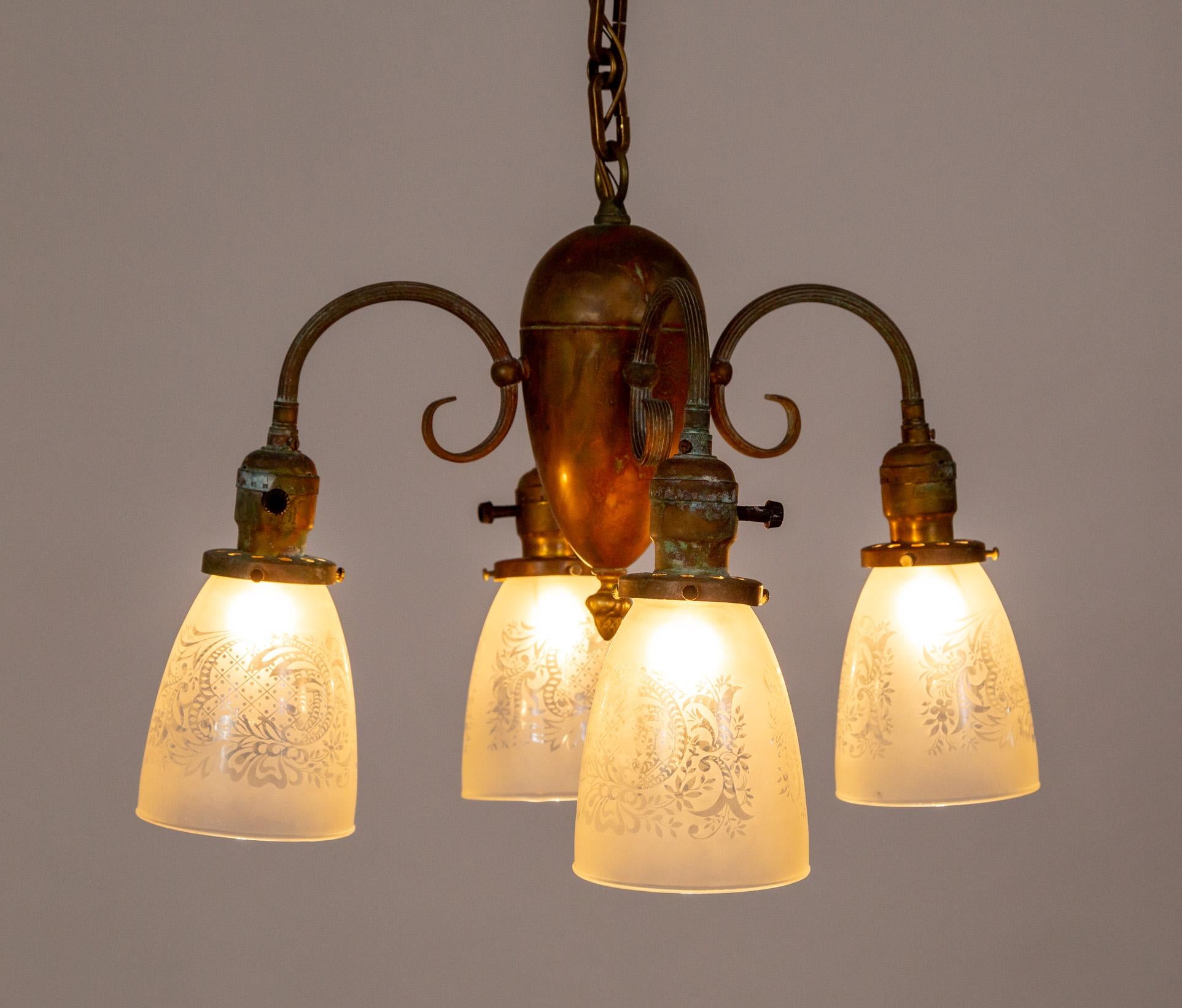 A Victorian chandelier with a rich brown patina and 4 downward lights with the original, etched shades and new, decorative chain.  It has switches on the sockets so that one or all lights can be on at a time.  Circa 1900.   Newly rewired. 15