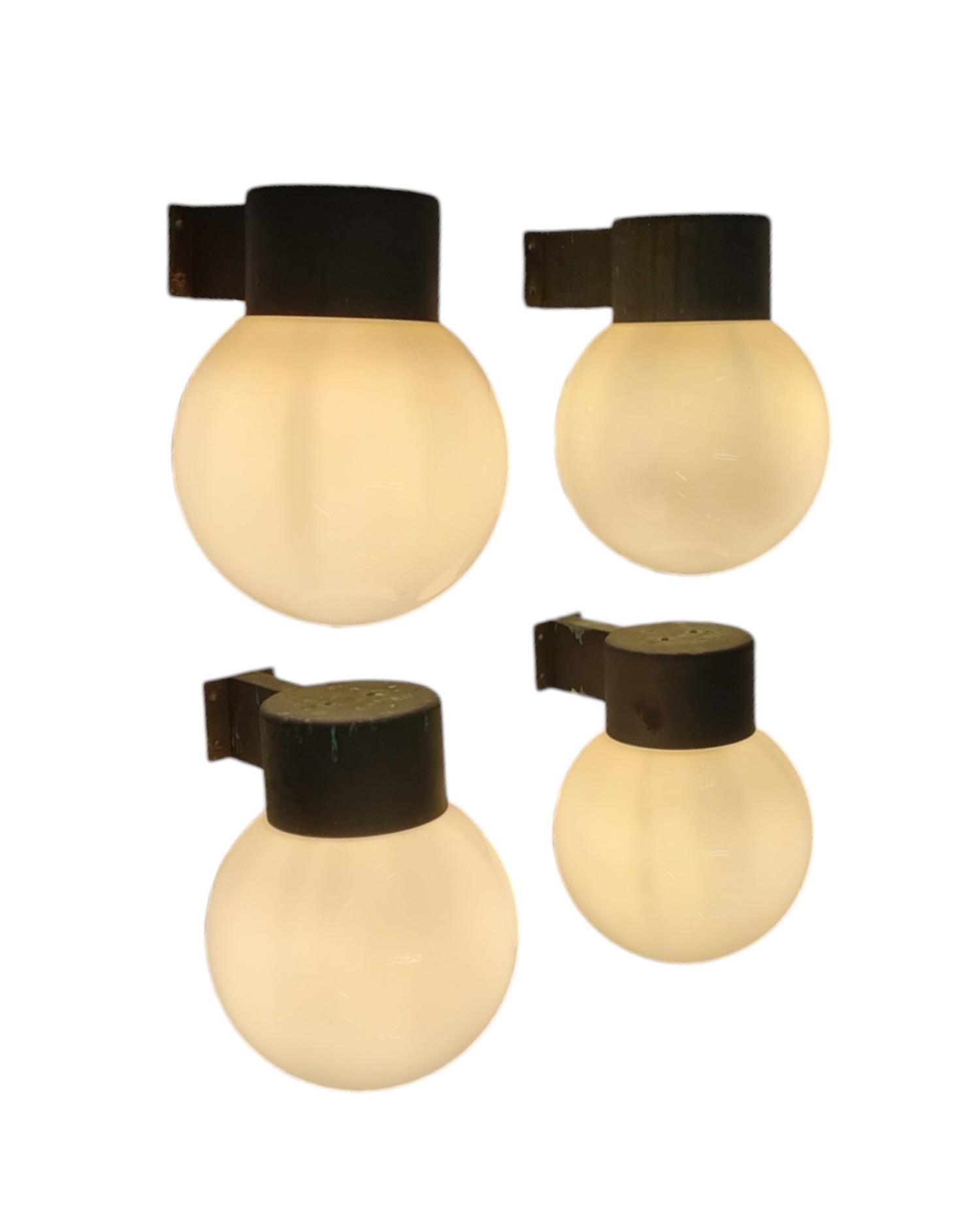 Two pairs (4 lamps) of elegant wall mounted lamps model 17-037, designed by Lisa Johansson-Pape and manufactured by Orno Oy in Finland in the 1960s. Each lamp features a patinated copper metal base with an opaline glass shade. 
They have kind of a