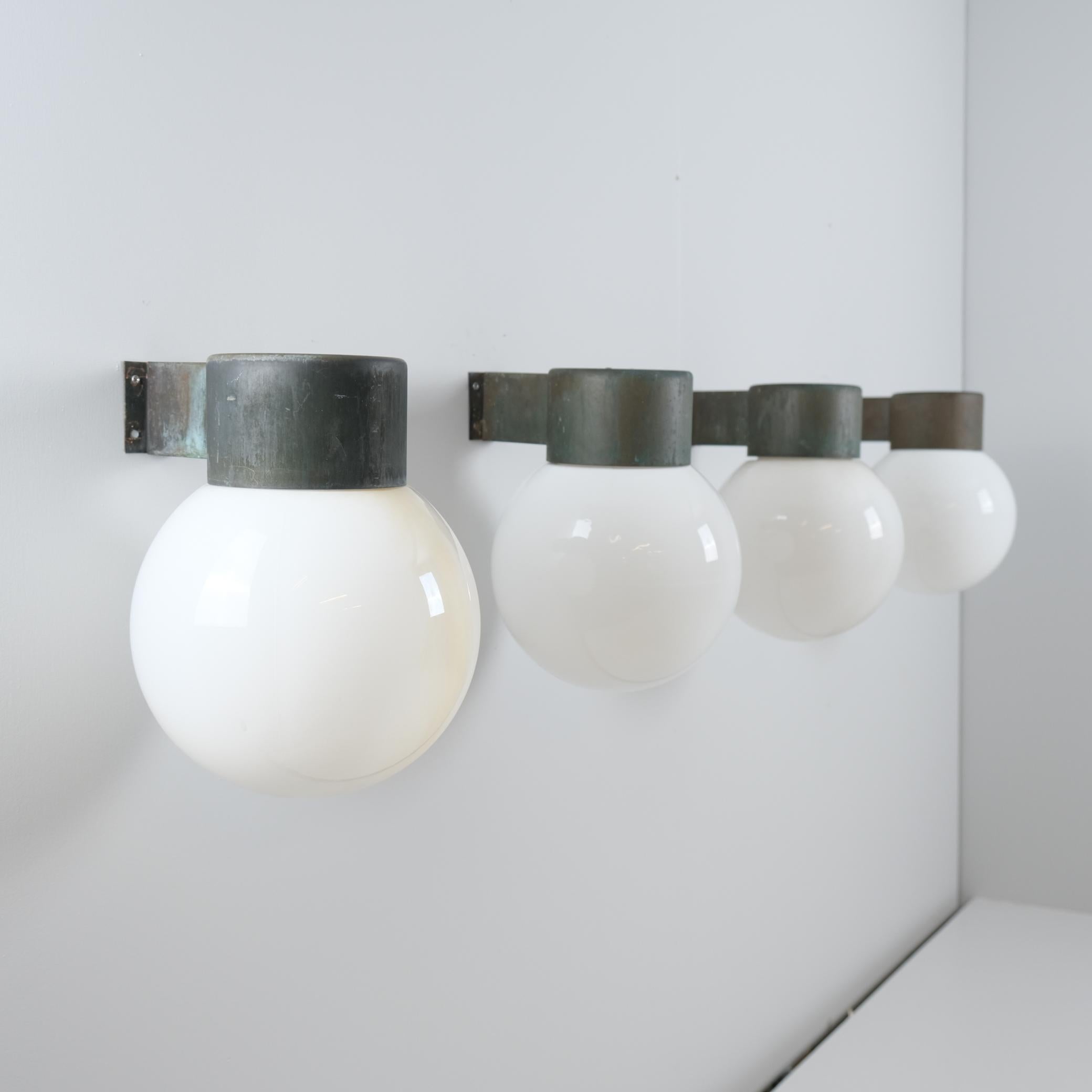 Zwei Paare (4 Lampen) von Wandleuchten Modell 17-037, entworfen von Lisa Johansson-Pape und hergestellt von Orno Oy in Finnland in den 1960er Jahren. Jede Leuchte hat einen Sockel aus stark patiniertem Kupfer und einen Schirm aus Opalglas. 

Sie