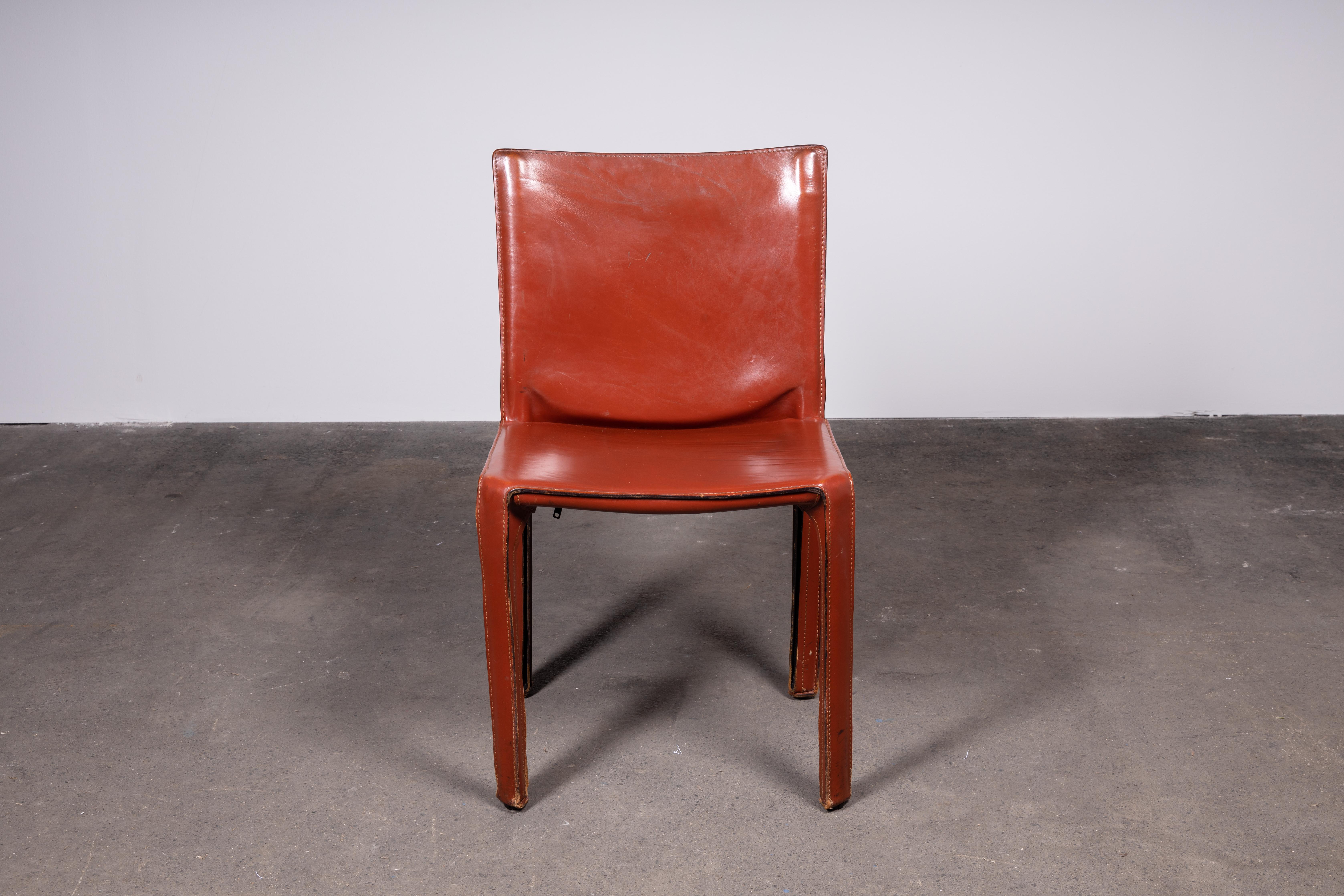 Set of four Mario Bellini CAB 412 chairs, made by Cassina in the 1980s. Flexible steel frame covered with a skin of high quality cognac / Russian Red (also known as Bulgarian Red) saddle leather. This elegant, versatile chair is equally suitable for