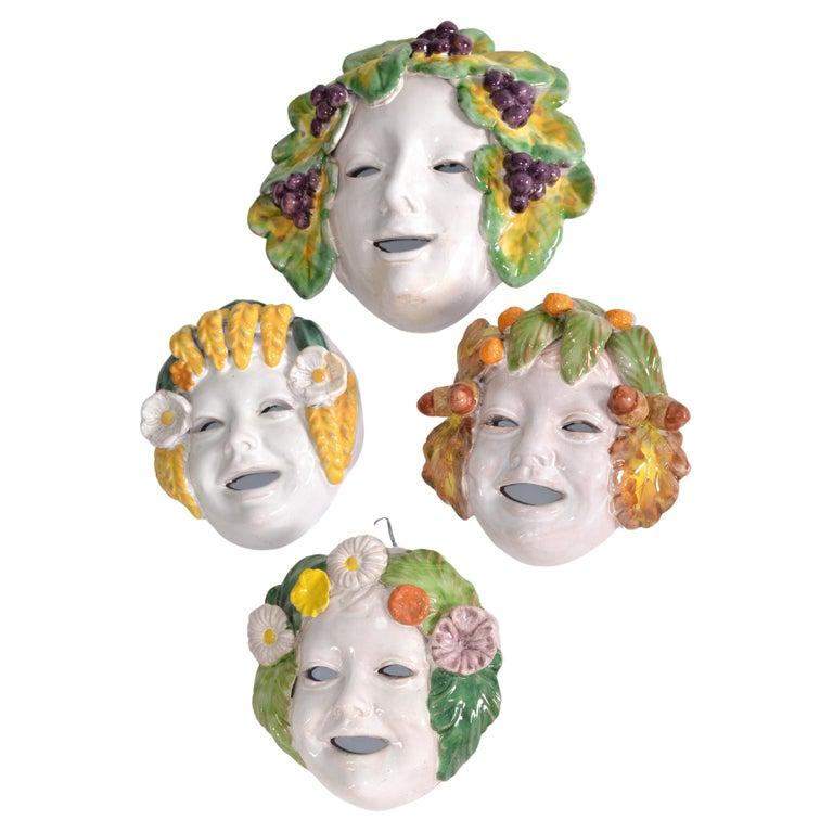 Set of 4 hand-painted and hand-crafted Majolica Masks, one of them is way bigger than others, Italy circa 1960.  
The pieces showcases Italian craftsmanship and feature beautiful colors and textures that would add character to any collection.