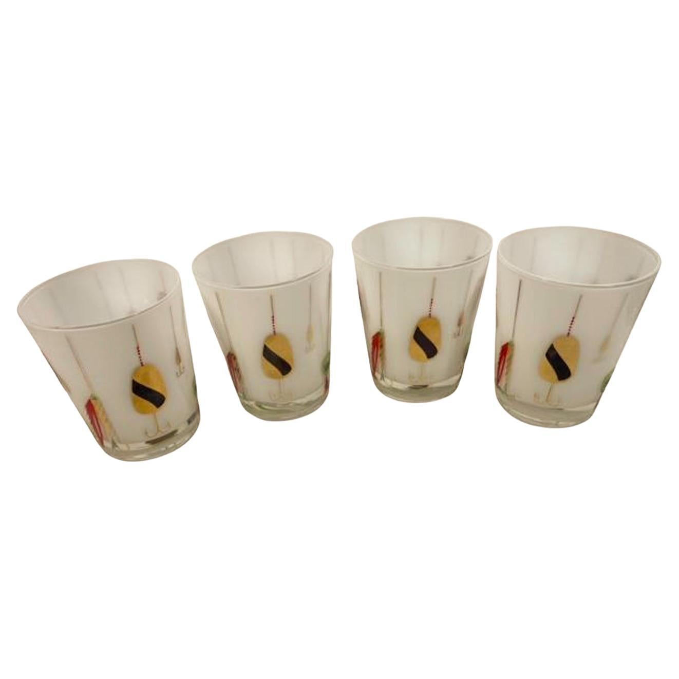 Set of four mid-century modern double old fashioned glasses with fishing lures in colored enamels and 22 karat gold with raised textured designs on clear glass with white frosted interiors.