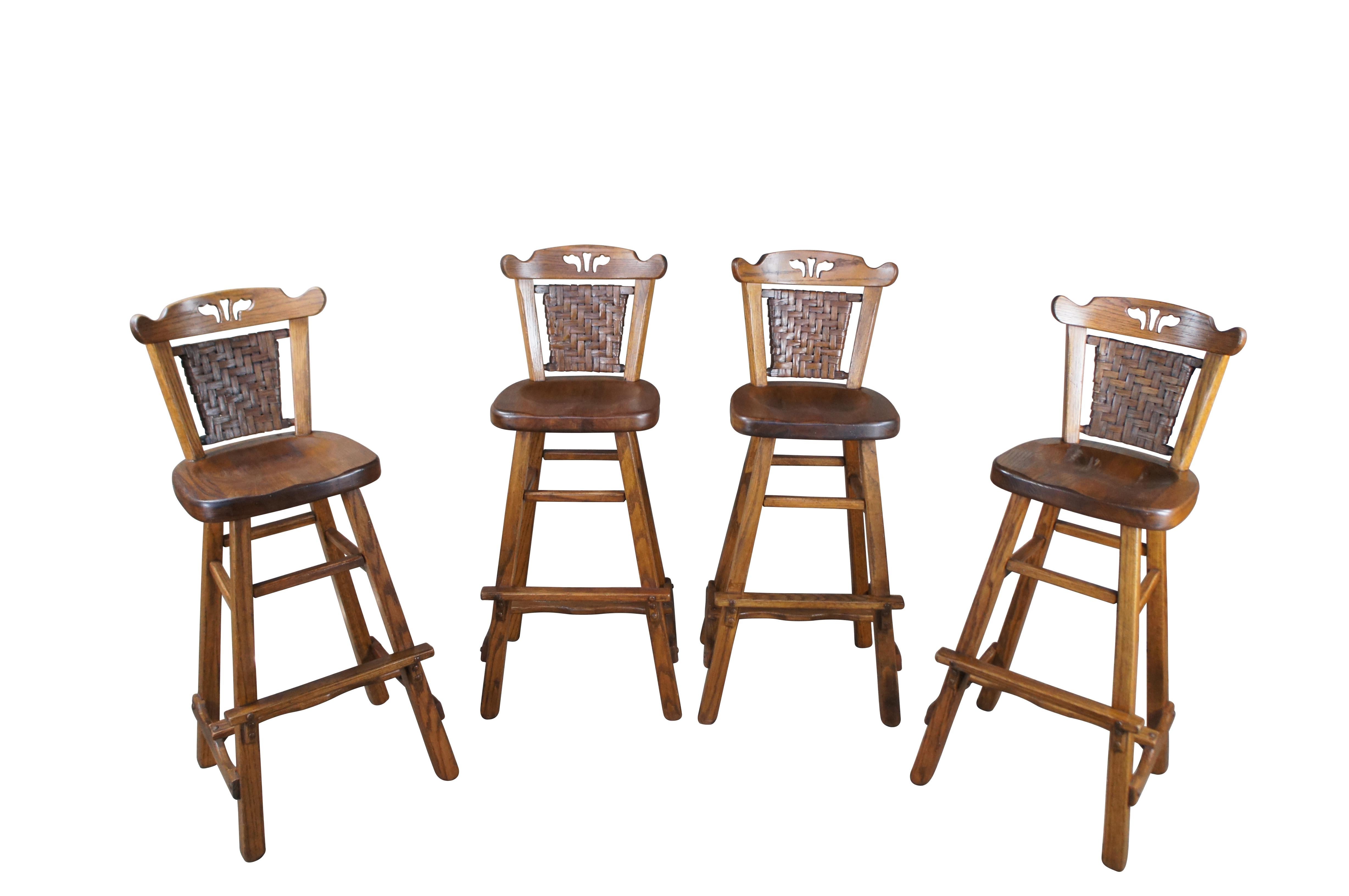Four mid century, circa 1940s, bar or counter stools by Old Hickory Furniture Company of Martinsville, Indiana. Features a primitive tapered Adirondack design with pierced / woven rattan backs.  Rustic, log cabin, lodge, farmhouse.

History
In the