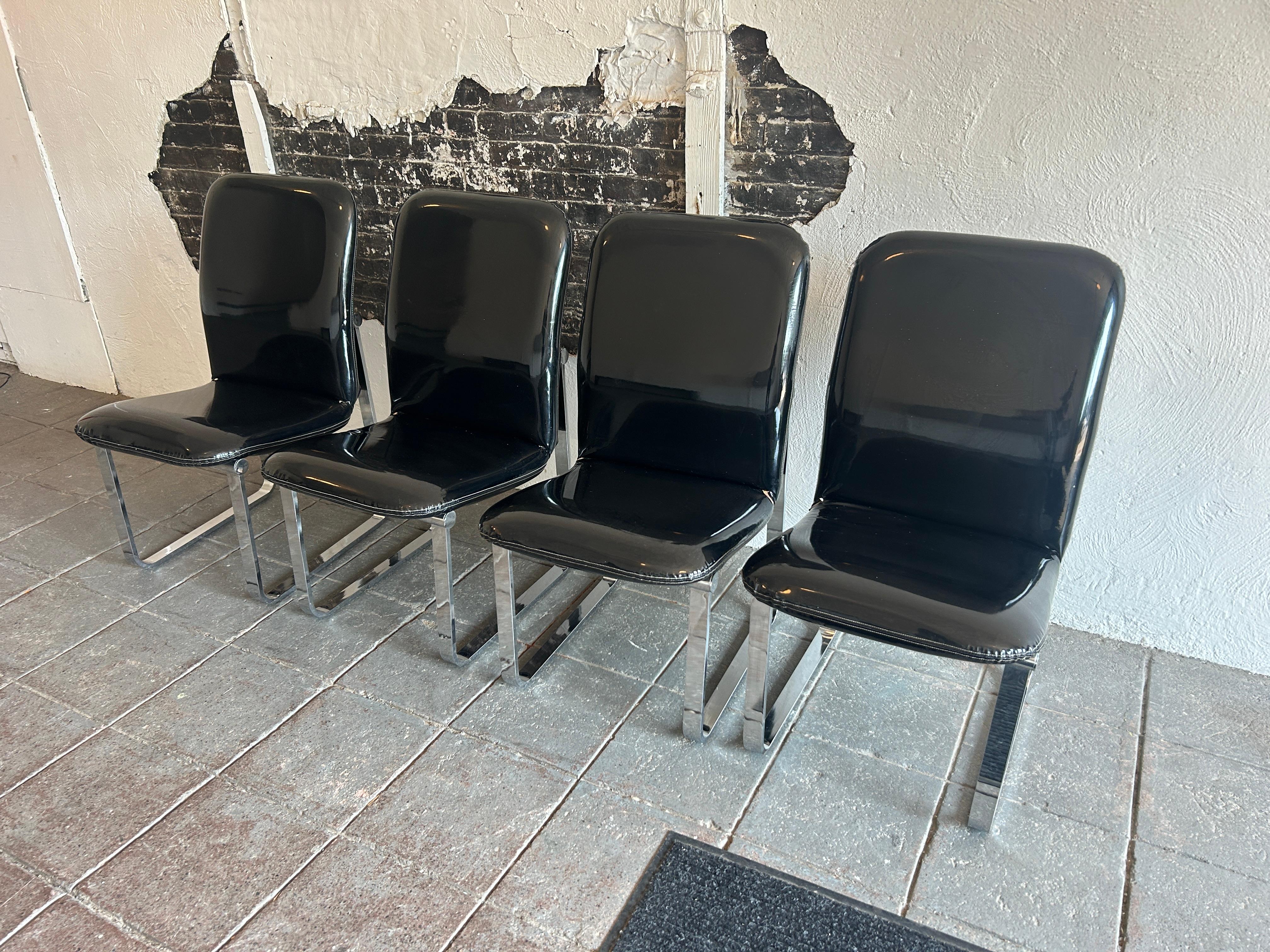 Set of (4) Mid century post modern Black Glossy faux Patent Leather chrome cane dining chairs by DIA. Great set of 1980's Post Modern chairs. Super high Glossy Black upholstery with solid steel chrome plated bases. All (4) chairs are in very good