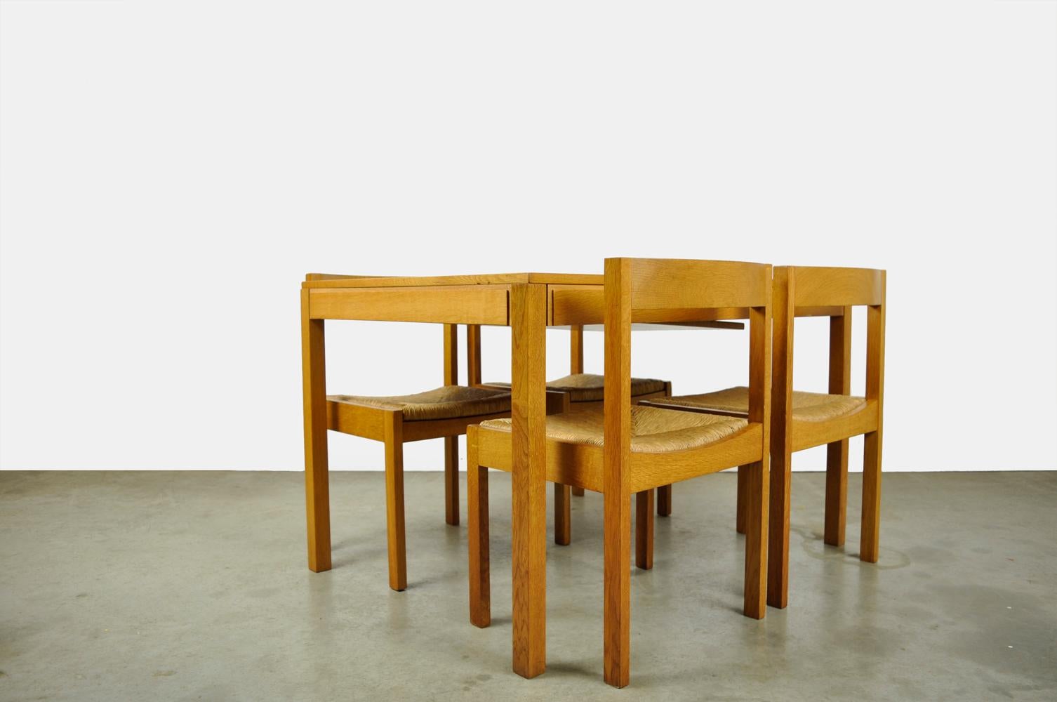 Vintage dining table set with four chairs designed by Gerard Geytenbeek and produced by AZS, 1960s Netherlands.The modern minimalist oak chairs have a wicker seat. The matching dining table can be extended to a 6-person table by means of an