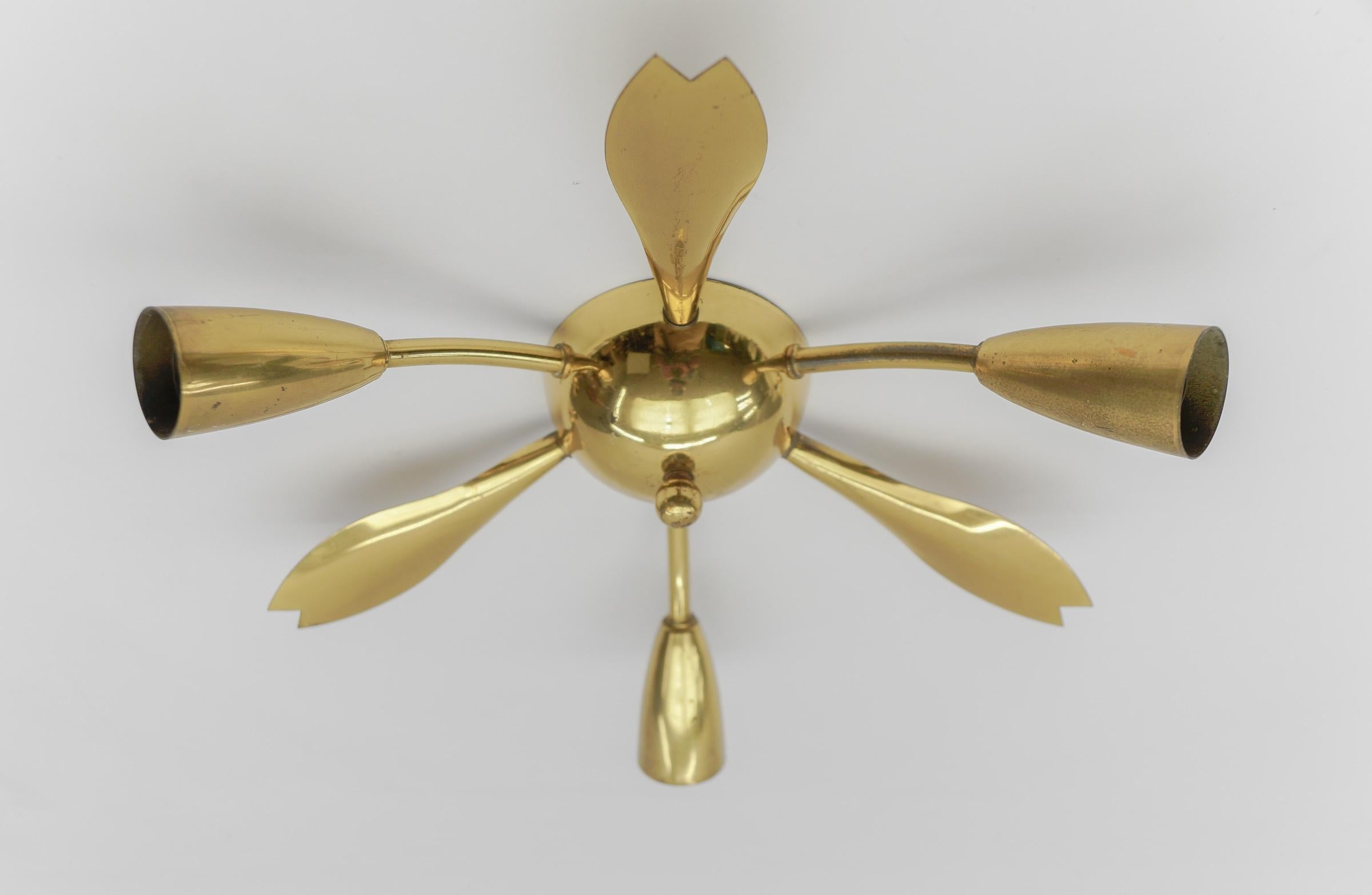 Midcentury 3-armed brass ceiling lamp. In the manner of Arteluce.

Rare and elegant midcentury ceiling lamp, 1950s. Executed in brass and metal.

The lamp is executed with 3 x E14 Edison screw fit bulbs. It is wired and in working condition. It runs