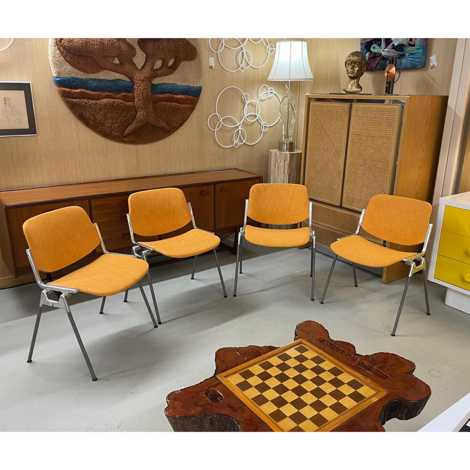 Group of four DSC 106 Giancarlo Piretti chair for Castelli stackable chairs. The iconic chairs have all new orange upholstery. The aluminum metal frame frames are original. Our restoration team had to source replacement feet all the way from France!