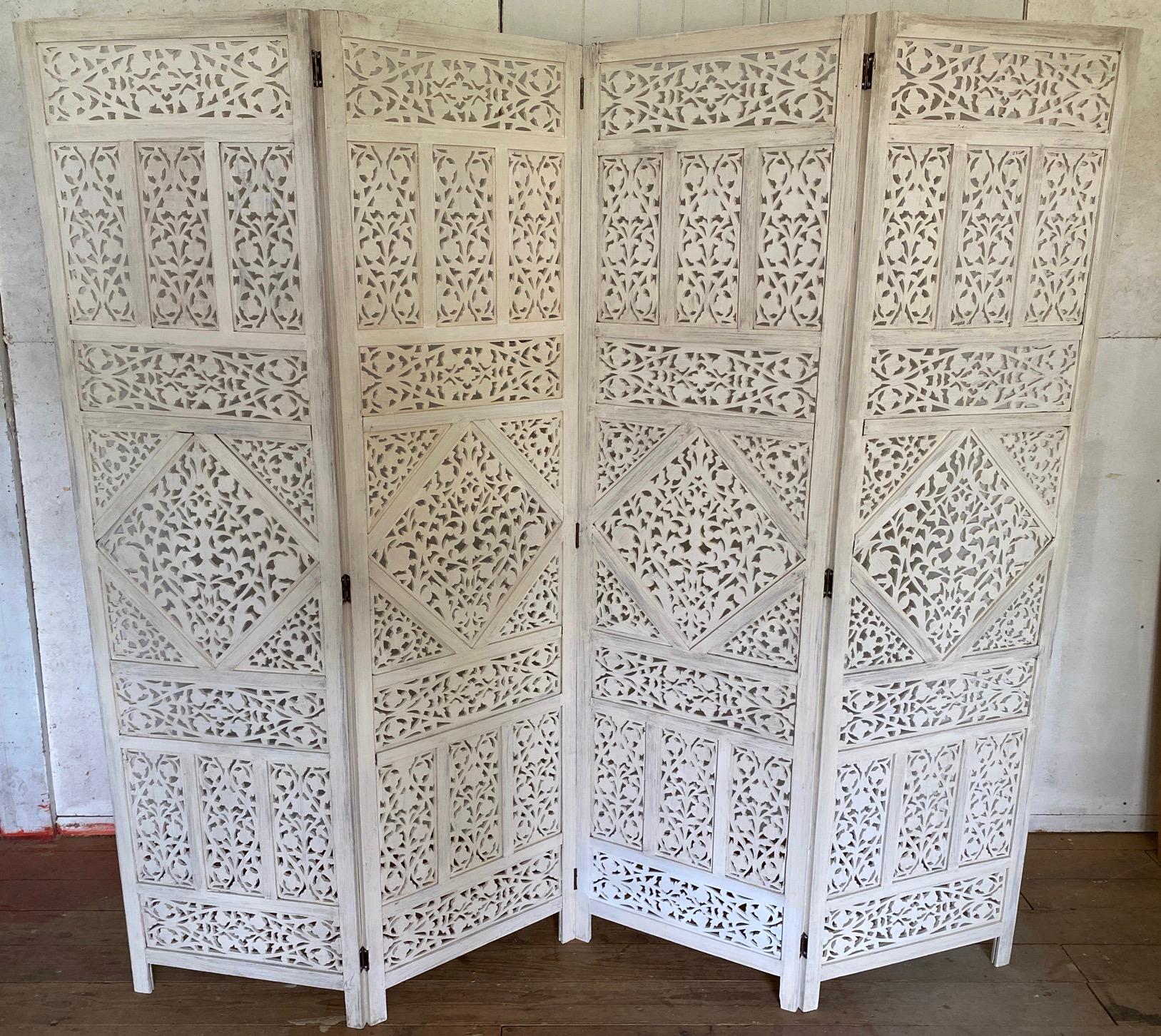 White washed Anglo-Indian 4 panel folding screen or room divider. Elaborately carved wood screen from the early 20th century. This screen is covered with stunningly intricate hand carved details, a great example of the Indian carving mastery. 
Use