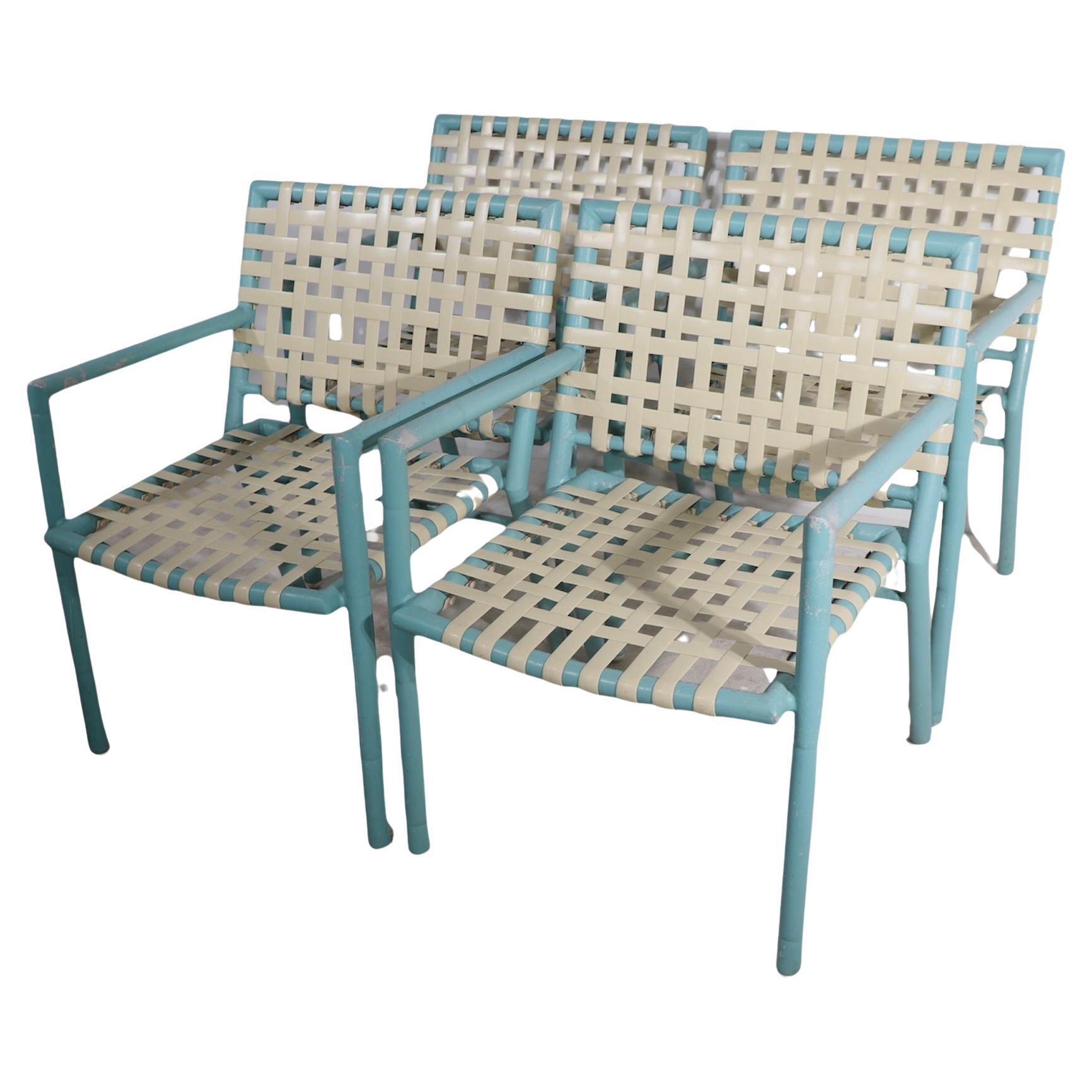 Chic set of vintage poolside, patio, garden, armchairs by noted American maker of leisure furniture, Hauser, after Brown Jordan. The chairs have tubular aluminum frames, with off white plastic weave pattern seats and backs. All are structurally