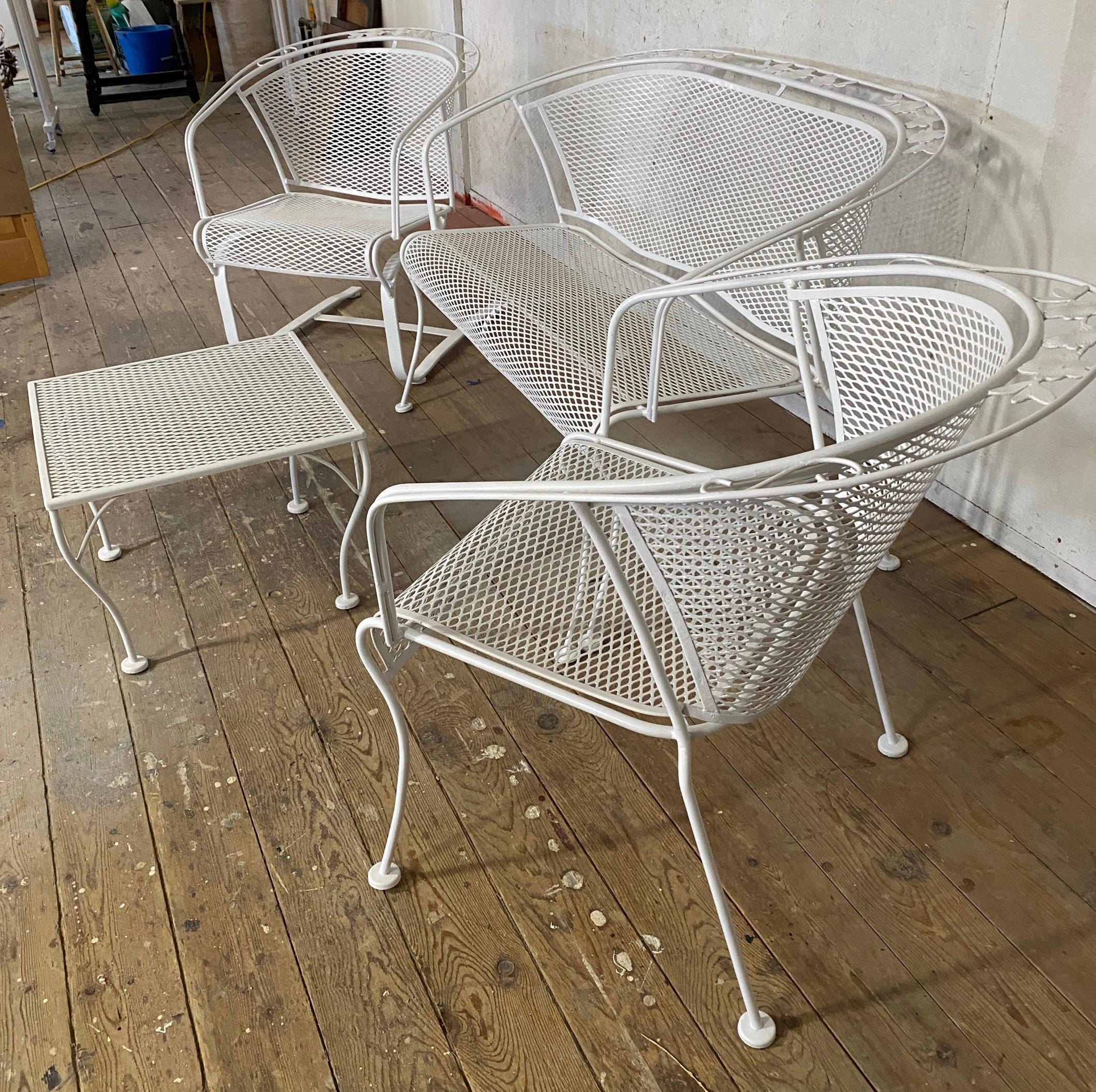 4 piece Salterini wrought iron and metal mesh garden seating ensemble consisting of a two seat sofa settee or loveseat, one cantilevered spring lounge chair, one arm chair topped off by a matching coffee table. All seating pieces have a barrel back.