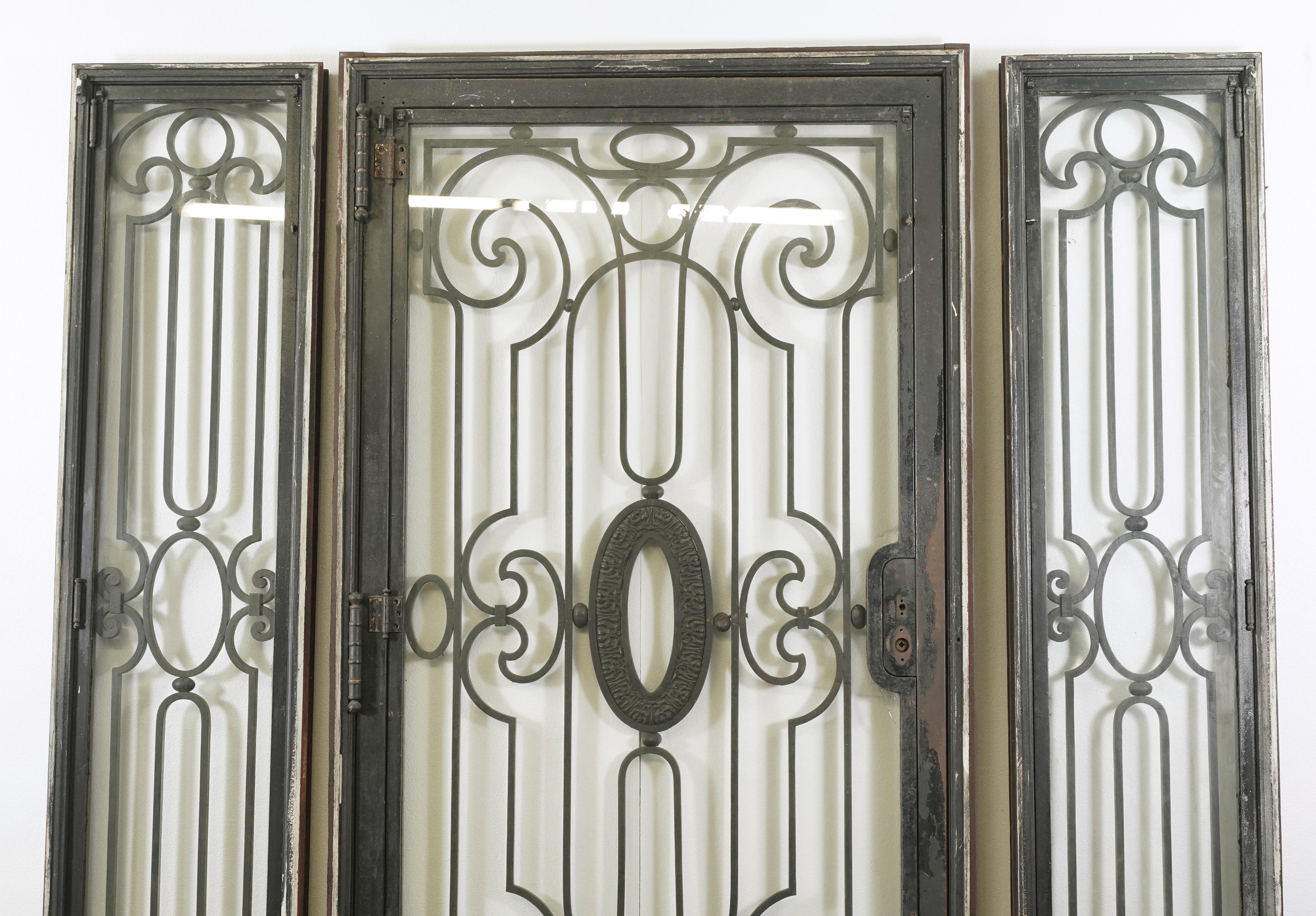 Early 20th Century four-piece door entryway set. Consisting of door, two sidelights and one transom. Restorable condition. Panels originally opened in for ventilation. Glass needs to be replaced. Minor rusting. Set needs to be stored. Sold as is.