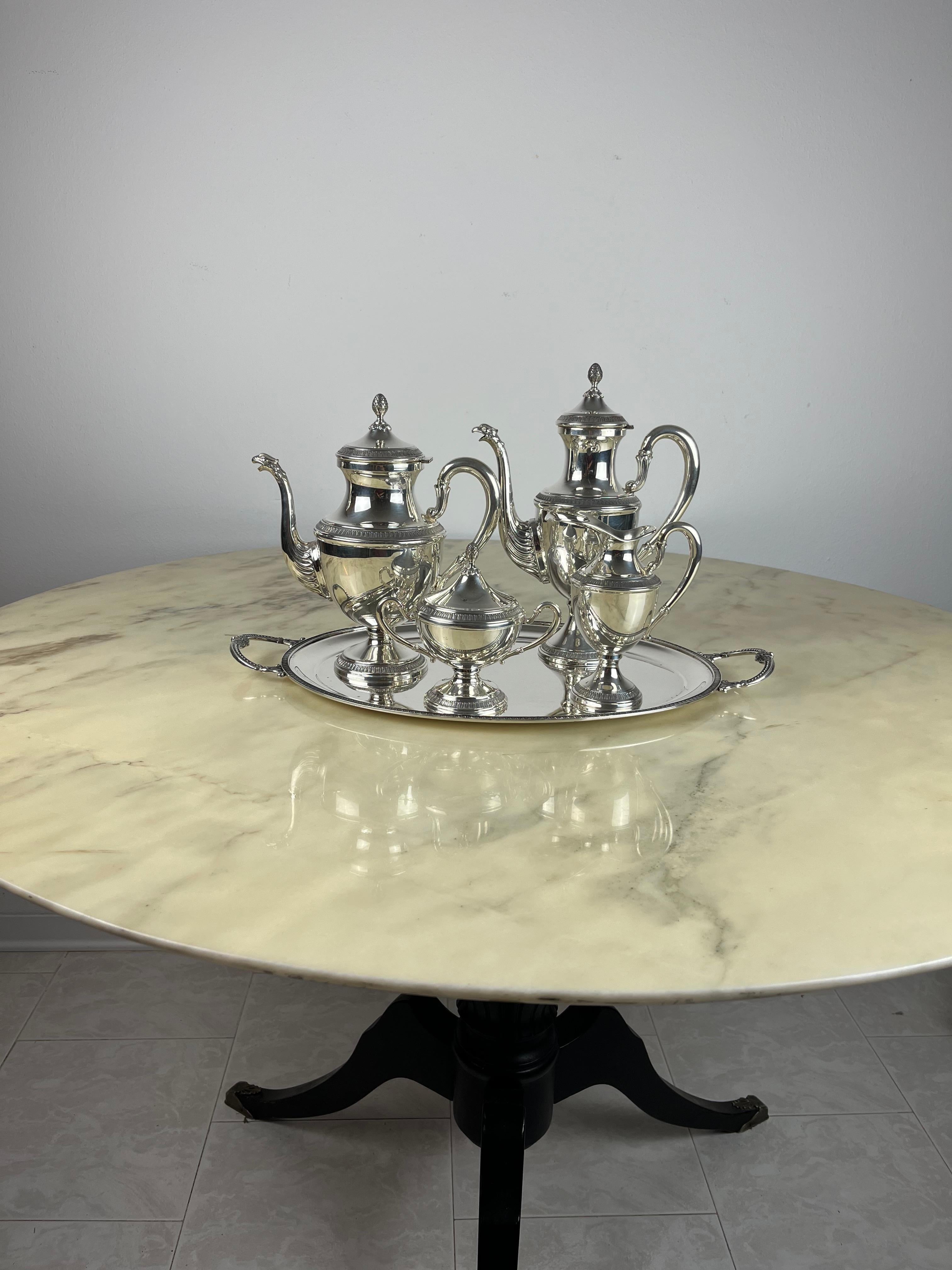 Servizio da tè e caffè 4 pezzi più vassoio, stile Impero, argento 800, Italia, 1980.
Il servizio ha un peso totale di 2,212 kg (caffettiera 439 g e misure 26 x 22 x 11 cm, teiera 383 g e misure 29 x 21 x 11 cm, lattiera 163 g e misura, zuccheriera
