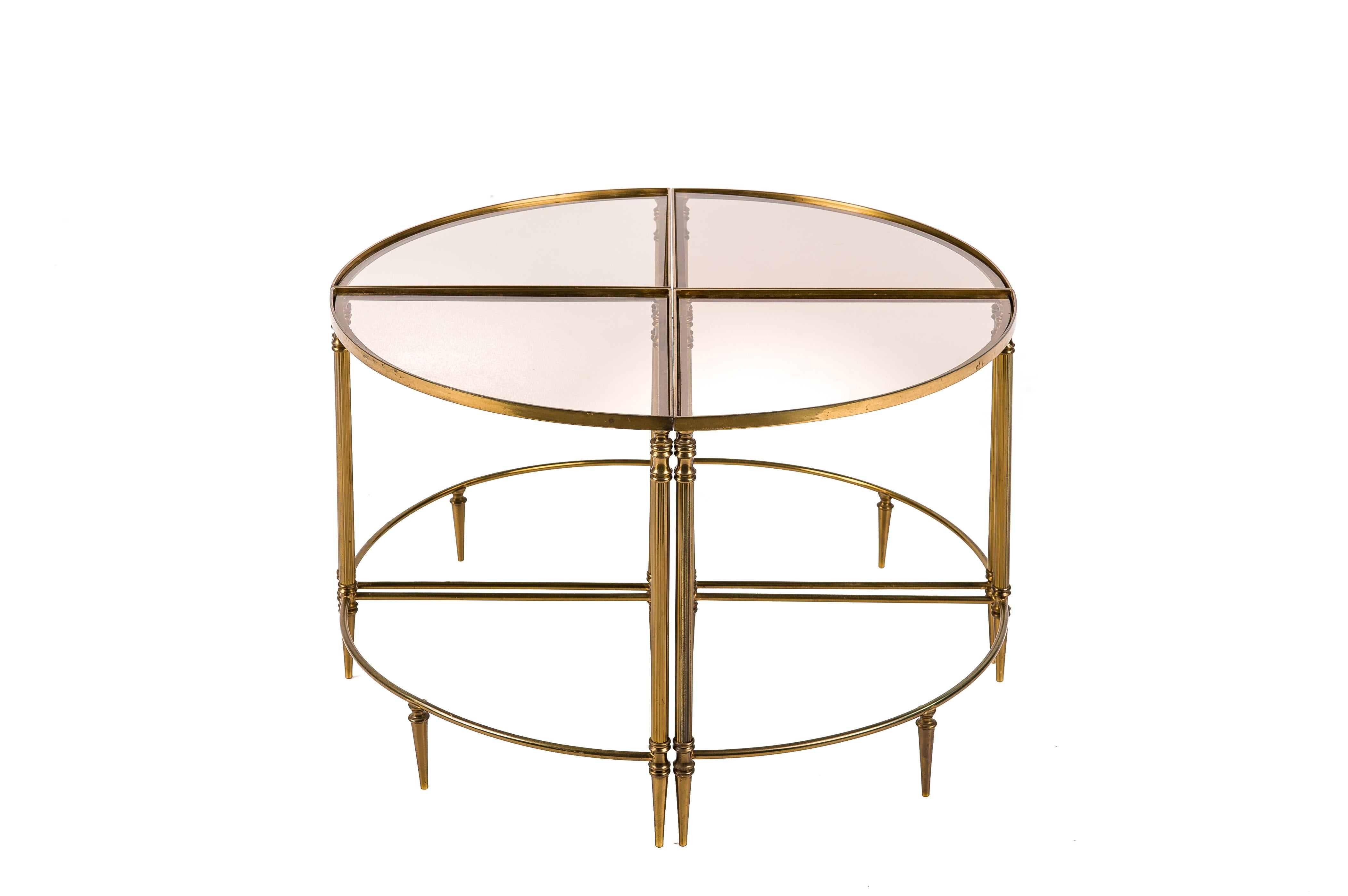 A beautiful set of four quarter-round nesting tables by Maison Baques, dating circa 1970. The 4 identical tables have neo-classical solid brass columns joined by a quarter-round apron and stretcher. The tables have a recessed smoked glass top. The