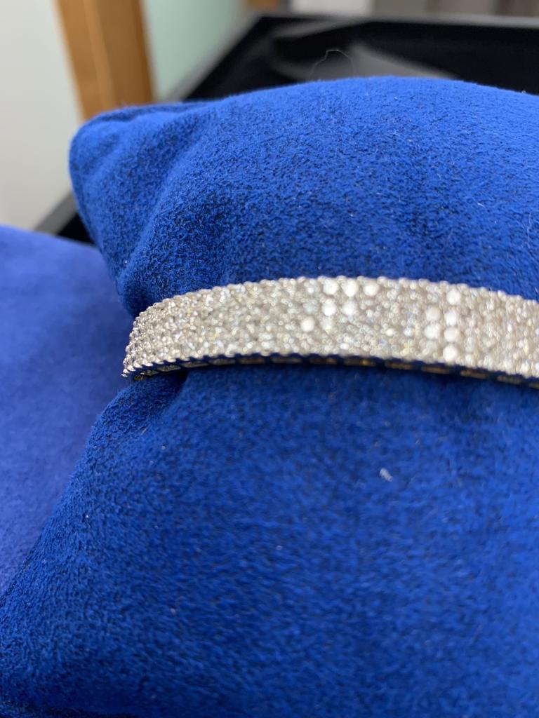  14k White gold bangle hinged with safety chain containing 4 rows of diamonds with approximately 4.25 carats total 
