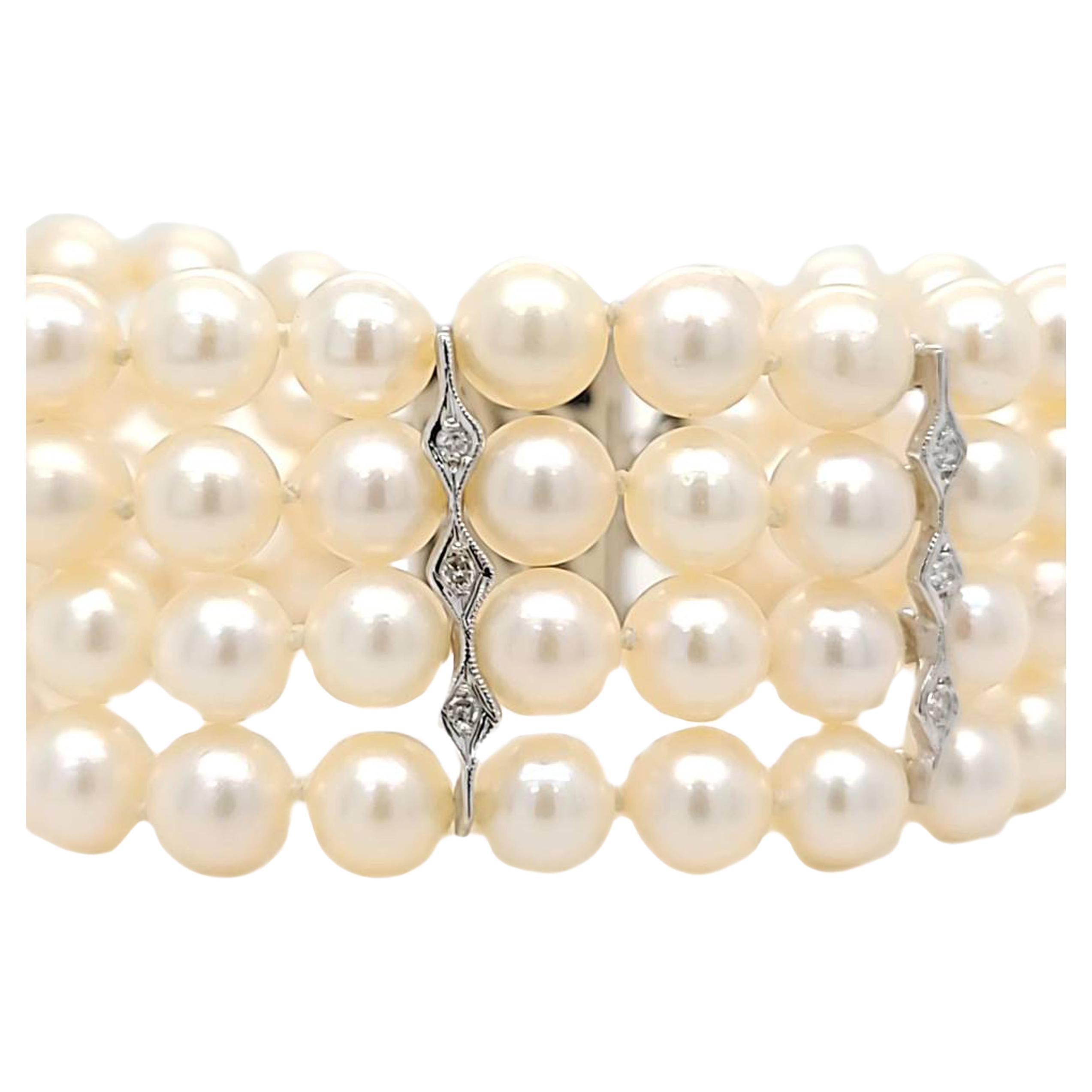 14 Karat White Gold 4 Strand Bracelet Featuring 84 Round Cultured Pearls Measuring 6.5mm to 7mm Accented by 15 Single Cut Diamonds of SI Clarity and G/H Color Totaling 0.15 Carats. 6.5 Inches Long with Box Clasp and Figure 8 Safety.