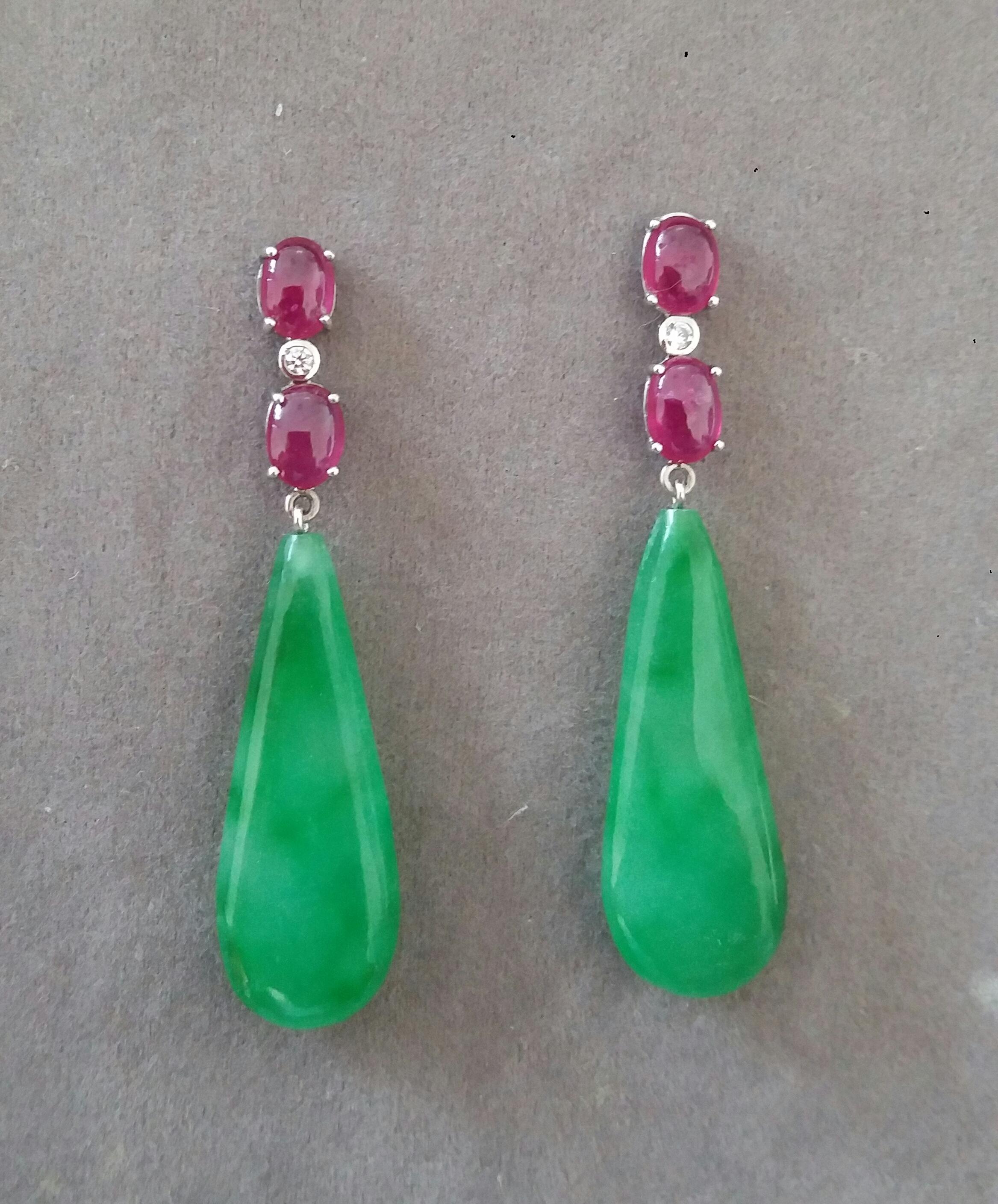 Elegant and completely handmade Earrings consisting of an upper part of 2 oval shape Rubies Cabs of 5 mm x 7 mm set together in 14 Kt white gold with a  small diamond in the middle, at the bottom 2 Burma Jade Plain Round Drops measuring 12x33