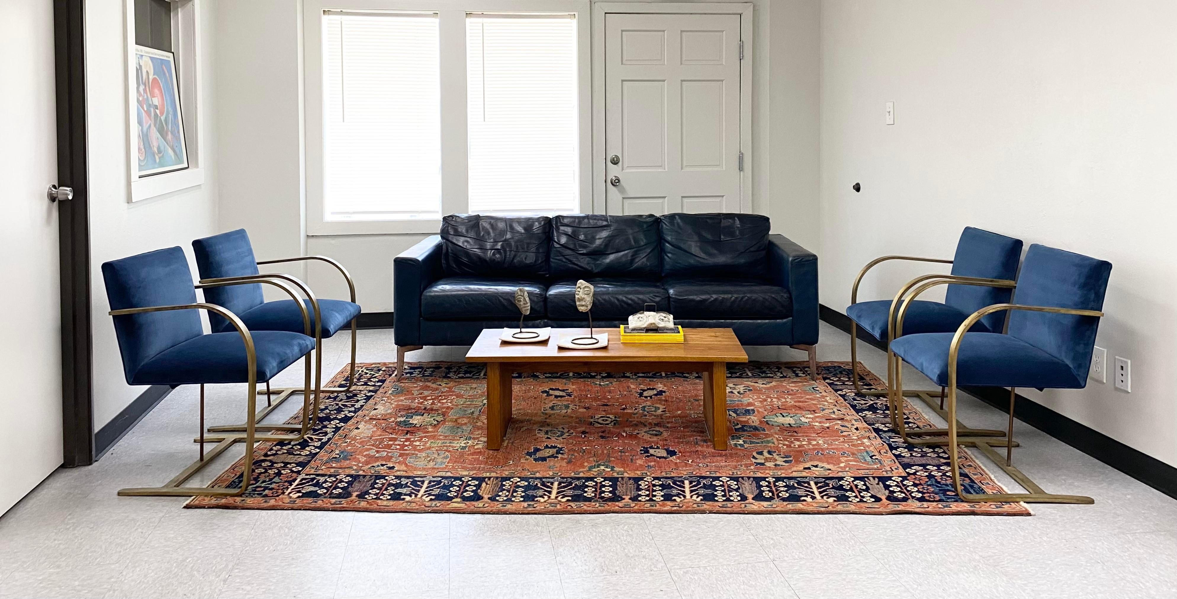 Striking pair of Brno armchairs, reupholstered in a rich sapphire blue cotton velvet that adds depth and luxury to the minimalist silhouette. These chairs are crafted with extremely heavyweight solid brass frames—unlacquered and beautifully