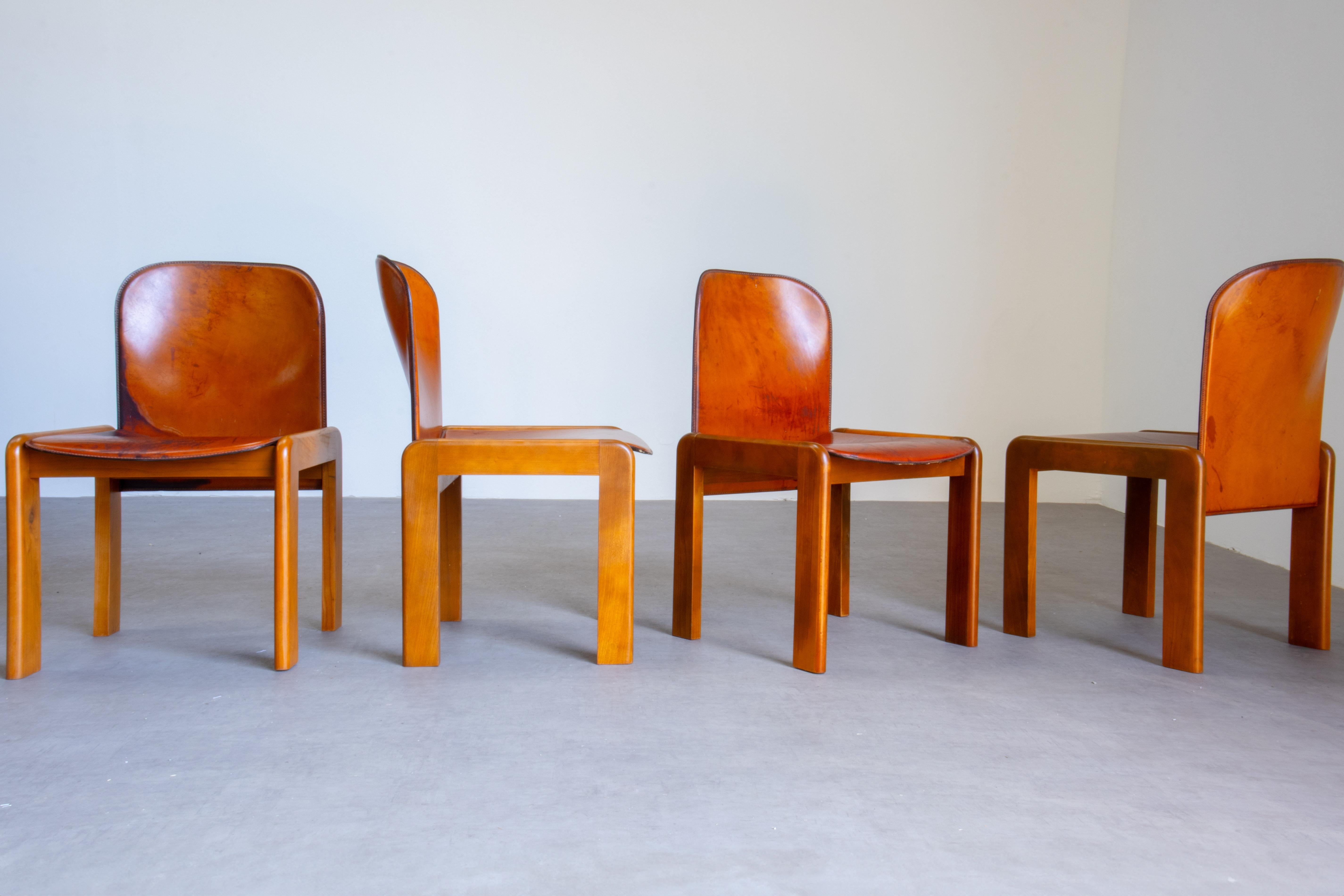 Set di quattro sedie da pranzo in pelle cognac e noce riccamente patinate, attribuite ad Afra & Tobia Scarpa. Sono stati prodotti in Italia negli anni '60. Presentano un rivestimento in pelle cognac e una struttura in legno di noce. Assomigliano