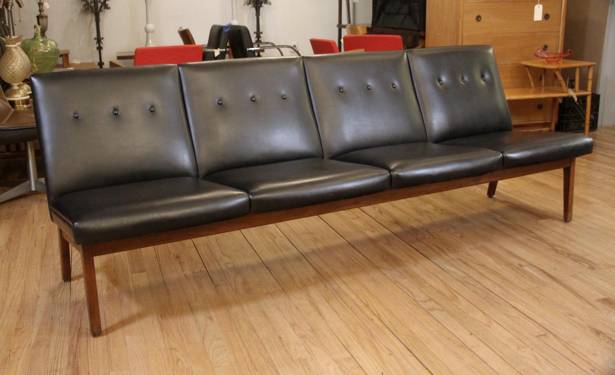 1970s Mid-Century Modern sofa or lounge with three buttons per section and wood legs. This can be seen at our 333 West 52nd St location in the Theater District West of Manhattan.