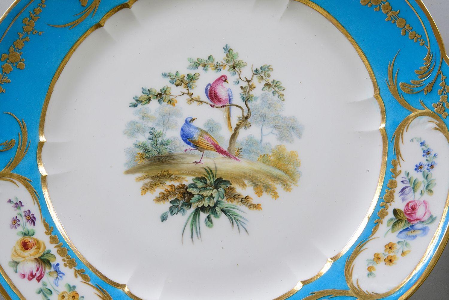 Un ensemble de bonne qualité de quatre assiettes en porcelaine de style Sèvres de la fin du XIXe siècle, chacune avec un fond turquoise, des panneaux insérés peints à la main représentant des fleurs colorées, le centre avec des paires d'oiseaux