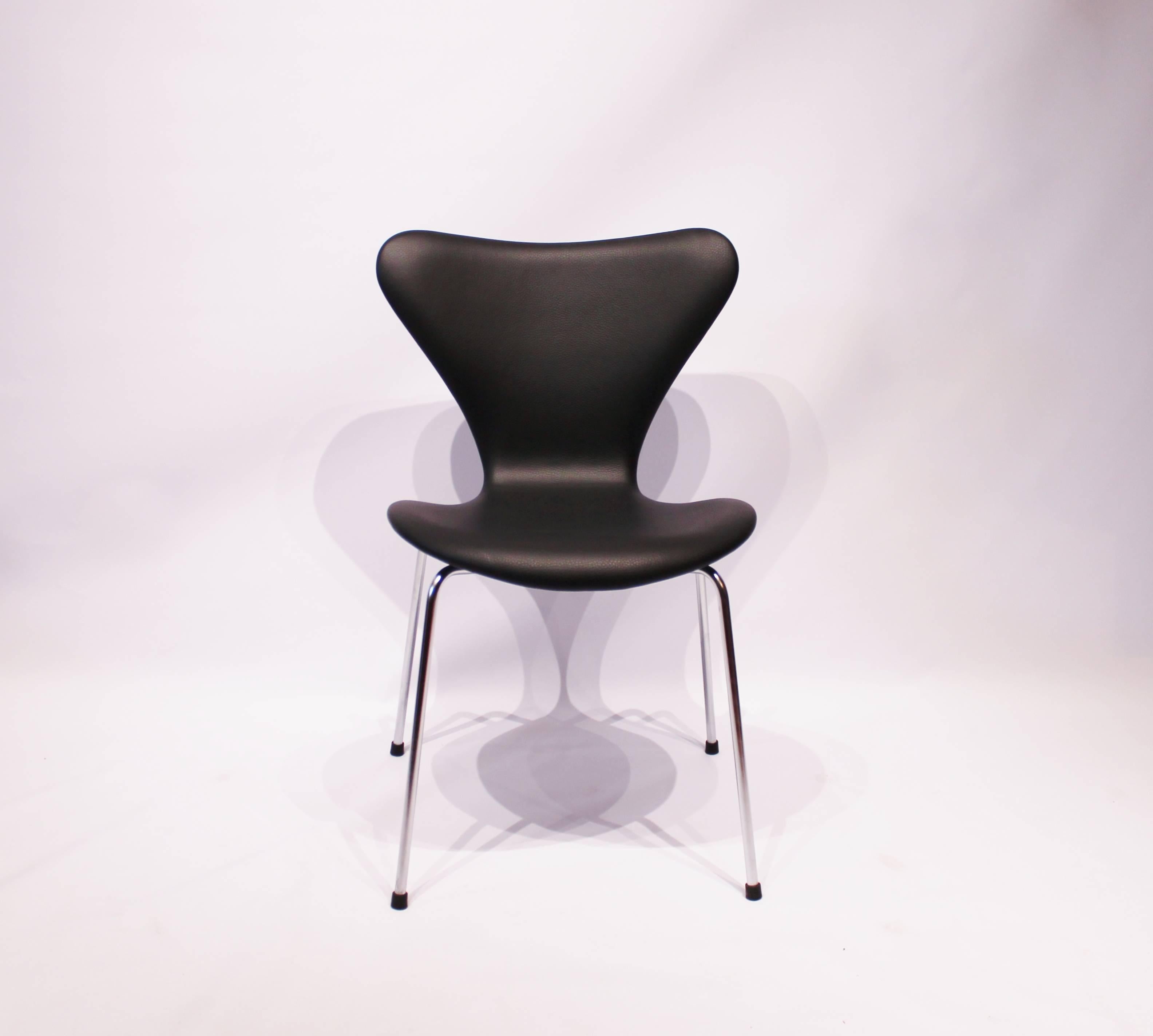 A set of four Seven chairs, model 3107, designed by Arne Jacobsen and manufactured by Fritz Hansen in the 1980s. The chairs are upholstered in black classic leather. We can upholster more chairs if needed, in any leather wanted.