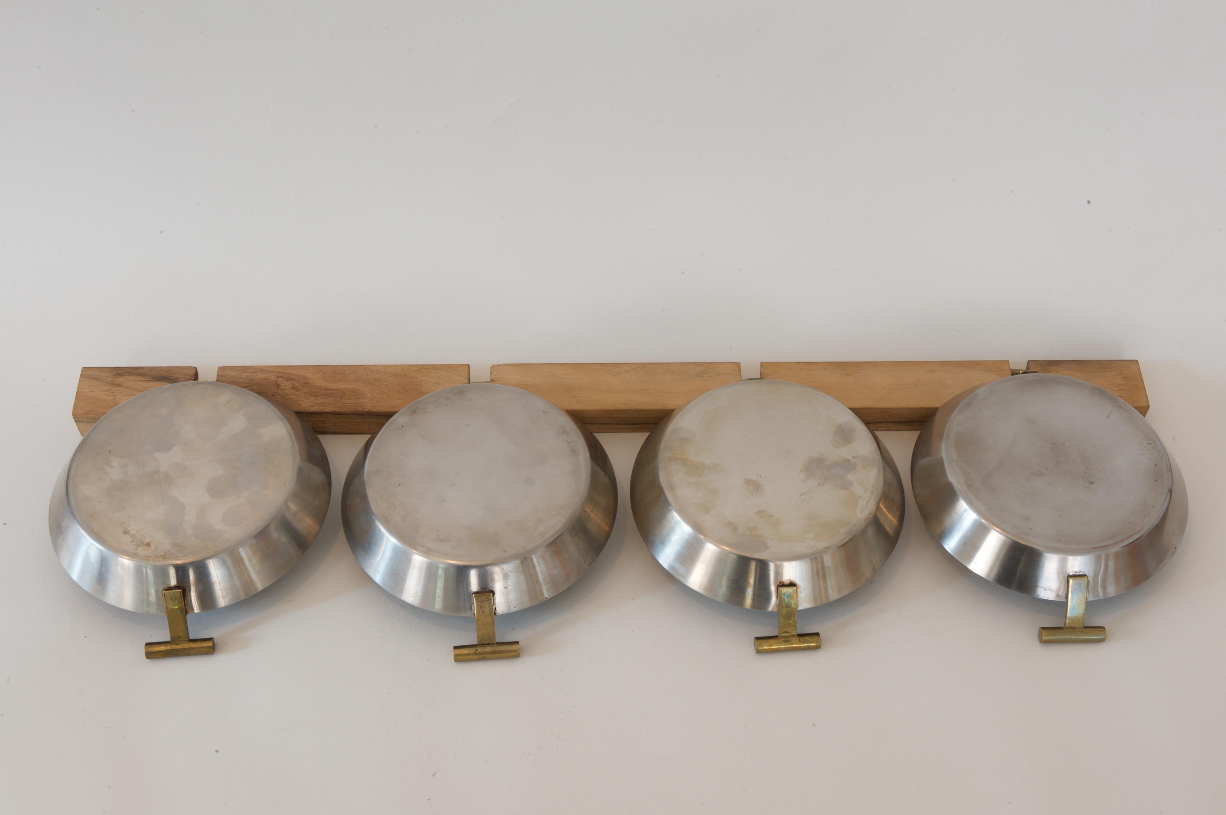 A set of 4 small Pans with a wooden rack
1950s by Carl Auböck

Nutwood rack, stainless steel, brass handles

Length with rack: 59 cm
Pan: 14.5 x 17.5 cm, H 4.3 cm / 5.7 x 6.89 in, H 1.69 in

Stamped on the brass handles: Auböck Logo, MADE IN
