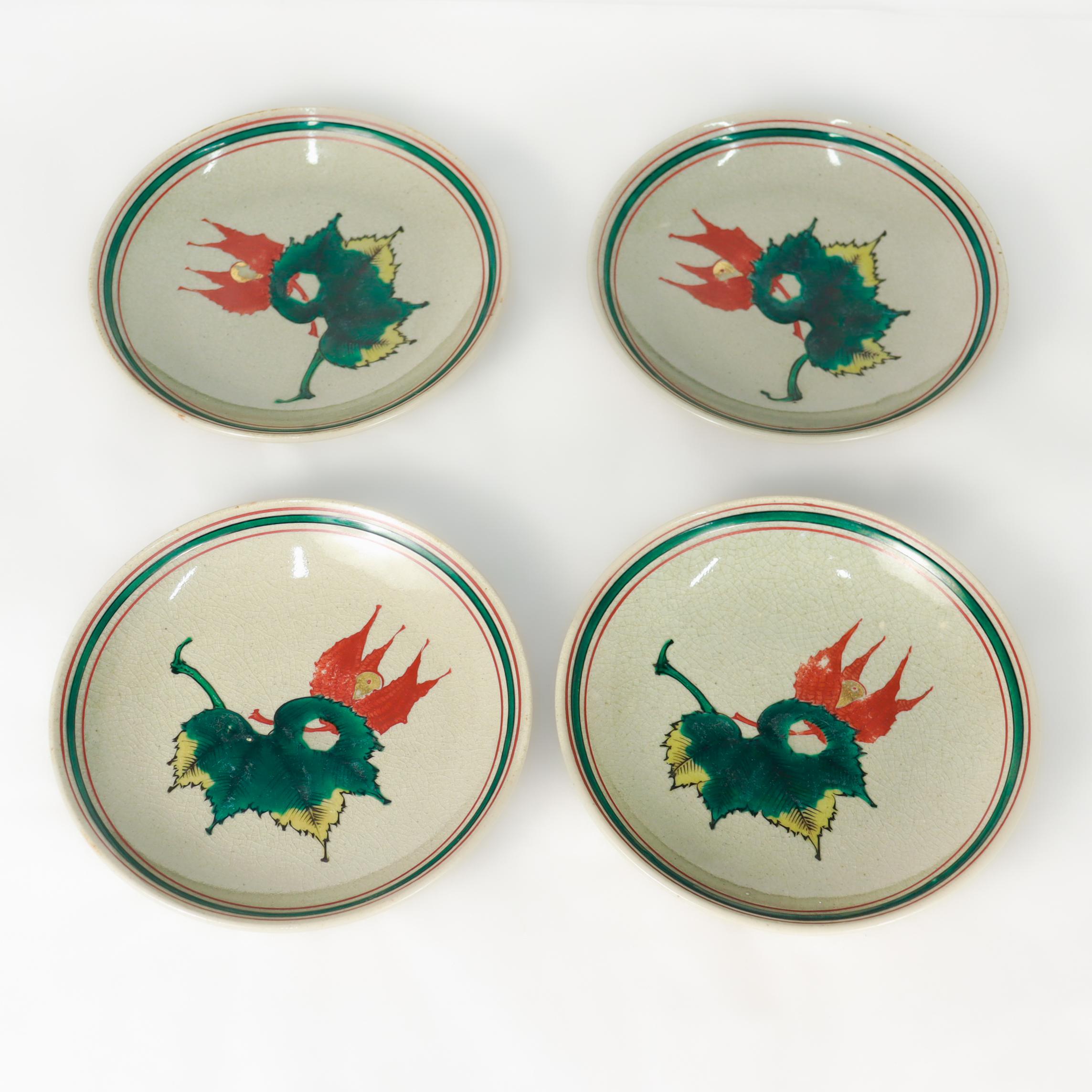 A fine set of 4 Japanese Kutanti porcelain plates.

Each with a pair of painted maples leaves to the center in green, reds, and yellows. The rim with red & and green stripes.

Made in Kanazawa's Kousen kiln in 1946 and likely funded by the Economic