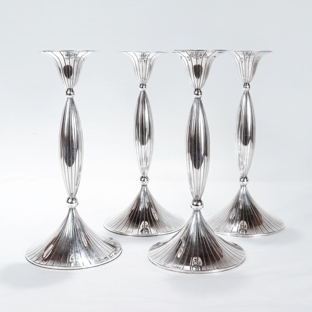 A very fine set of 4 tall Mid-Century Modern candlesticks.

In sterling silver.

Likely designed for Spritzer & Fuhrmann.

The set comprising of 4 cement-loaded tall candlesticks with engraved vertical line decoration to the candlecup, pedastal, and