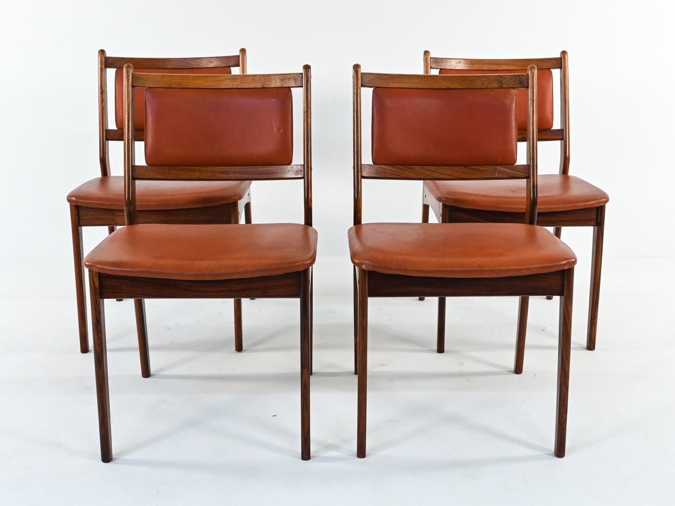 A gorgeous set of Danish mid-century side dining chairs crafted by Spottrup, c. 1960s, with label underneath seat. These stylish chairs are in the manner of Erik Buch's iconic designs, with sculptural, subtly angular frames of quality rosewood.